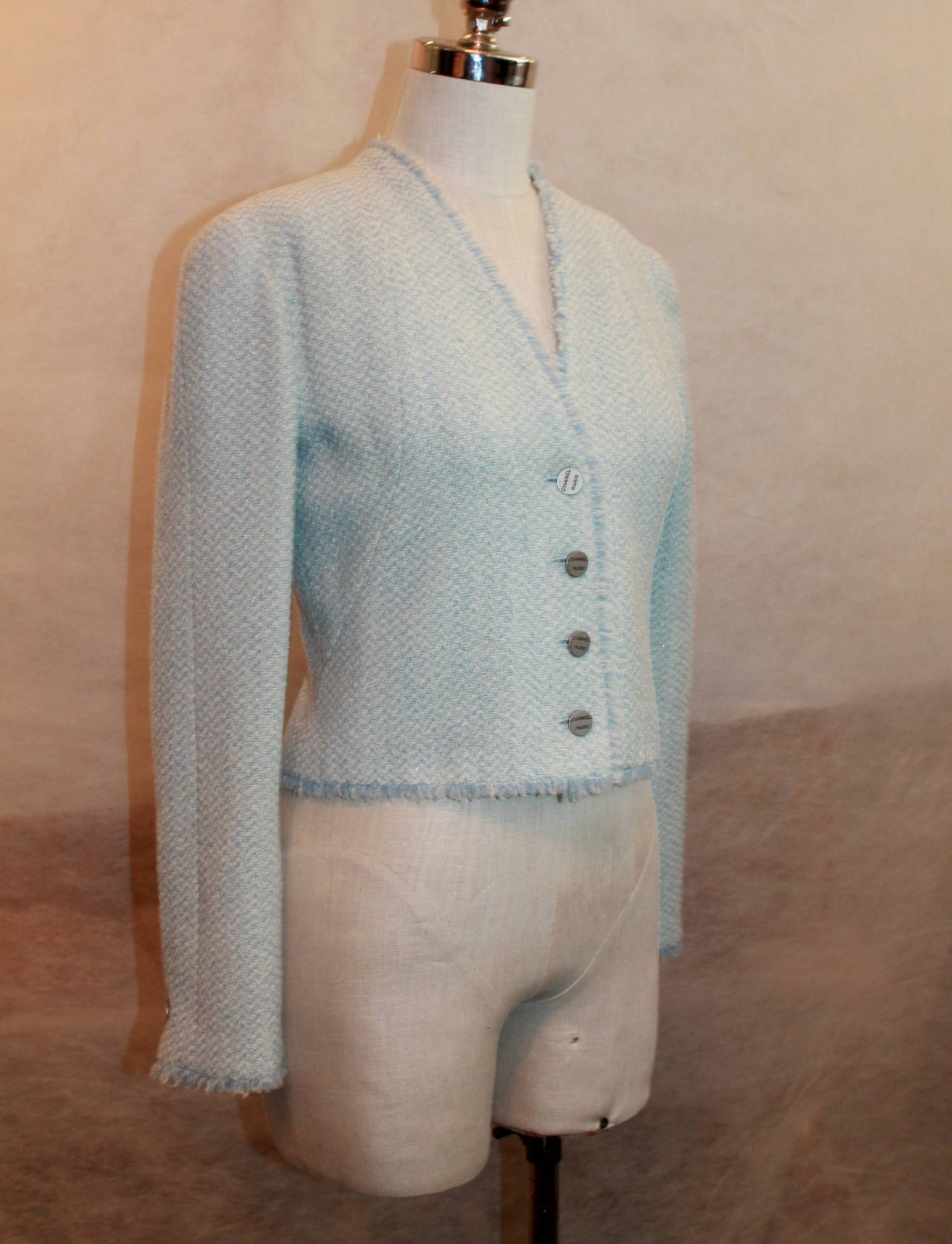 Chanel 2000 Baby Blue & White Tweed Crop Jacket with Fringe Trim - 38. This jacket is in excellent condition with light use. It is 62% wool, 26% polyester, and 12% nylon with a silk lining.

Measurements:
Sleeve Length- 24