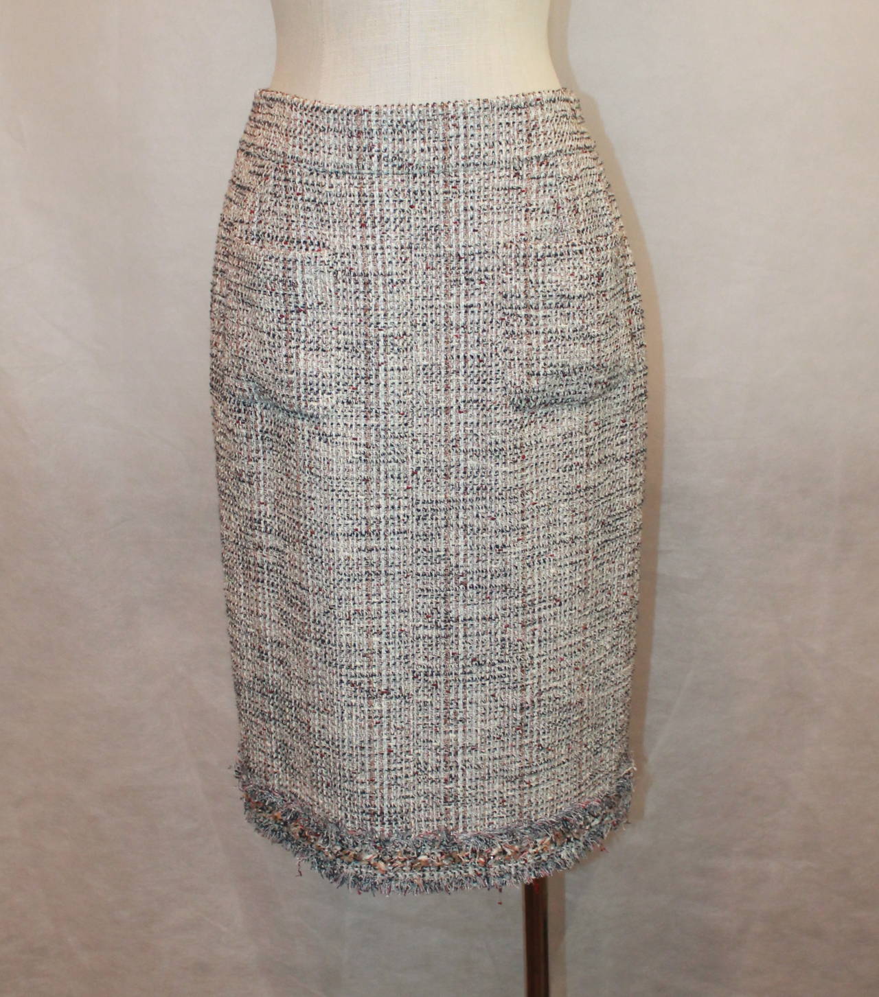 Chanel Beige & Earthtones Tweed 2-Pocket Skirt - 42. This skirt is in excellent condition with a layered fringe trim on the bottom. The tweed is a mix of beige, tan, navy, burgundy, and white. 

Waist- 29.5