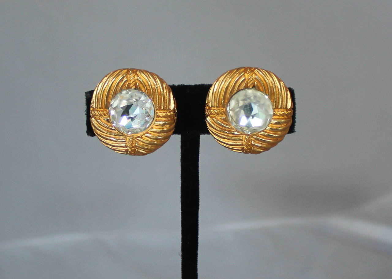 Chanel 1970's Vinatge Rhinestone & Goldtone Swirl Clip-On Earrings. These earrings are in good vintage condition with wear acceptable for its age. The rhinestone on one of the earrings is less brilliant and shiny. (last image)