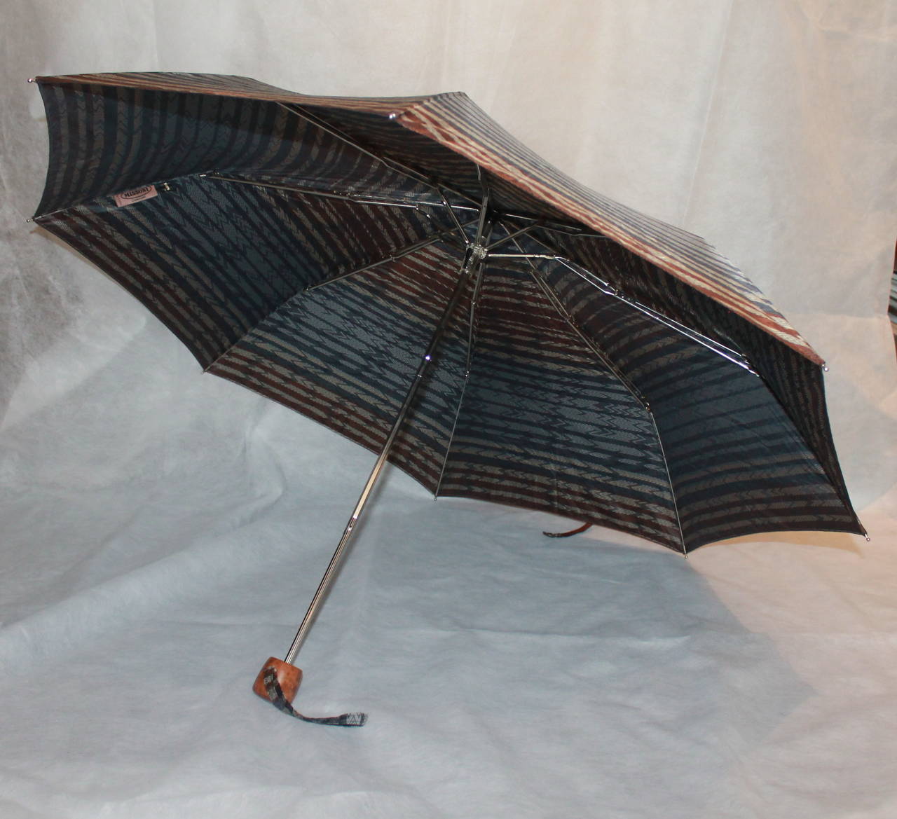 Missoni Grey & Brown Geometric Printed Umbrella with Cover. This umbrella is in excellent condition with light use. The handle is wooden and it has multi tones of brown and grey. 

Diameter when open- 38