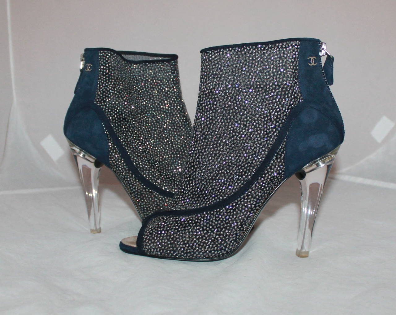 Chanel Blue Suede Peep-toe Glitter Bootie with Lucite Heel - 40. These shoes are in excellent condition with small glitter dots & a small metal Chanel logo in the back. They have minimal wear on the bottom as seen in image 5.