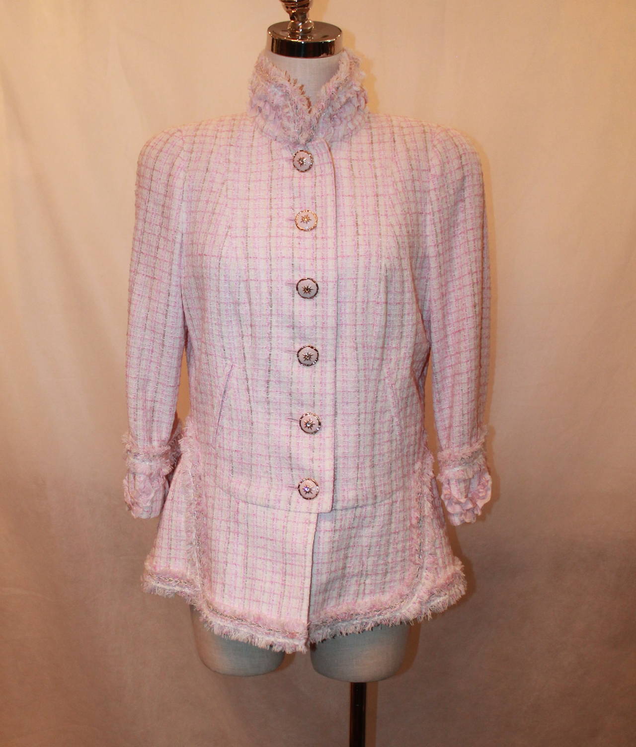 Chanel 2013 Light Pink & White Tweed Jacket with Fringe Detail - 44 - NWT. This jacket is in excellent condition and has a slight peplum. The fabric is a nylon and wool blend with 6 pink enamel & rhinestone buttons. The fringe trim is along the