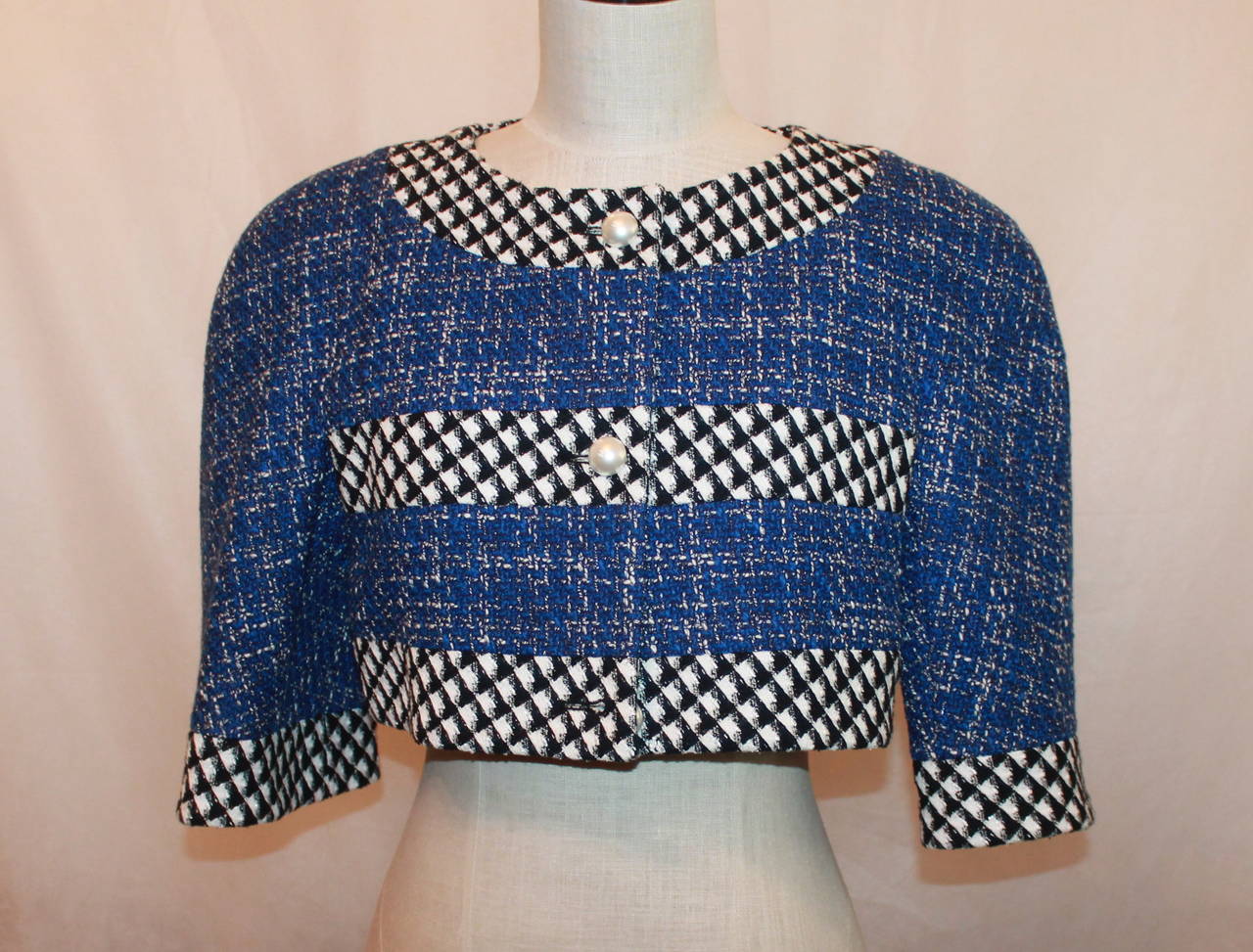 Chanel Blue, Black & White Tweed Crop Bolero with Pearl Buttons - 40. This piece is in excellent condition and is from 2010-2015. It is a wool and hound's tooth pattern. The pearl buttons have a 