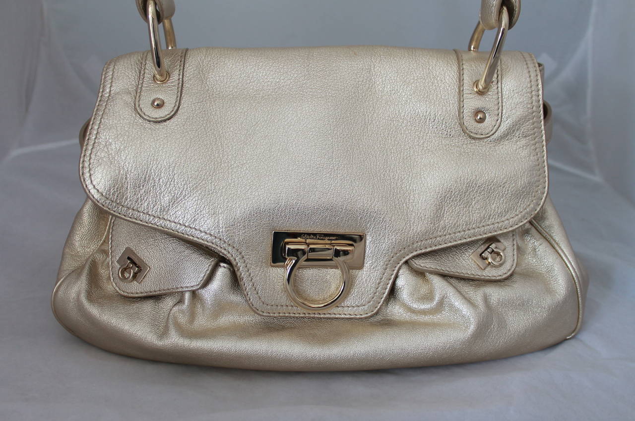 Salvatore Ferragamo Gold Metallic Leather Shoulder Bag GHW. This bag is in very good condition and has 2 front small pockets. It has slight markings on the front top, back top-right, and the inside (images 6-8). 

Measurements:
Height-