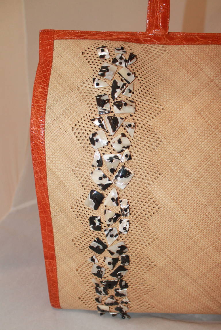 Nancy Gonzalez Beaded Raffia & Orange Croc Handbag. This bag is in good condition with a few beads being loose and some minor bottom wear. The beads are mother of pearl and the croc is genuine skin.

Measurements:
Height- 13