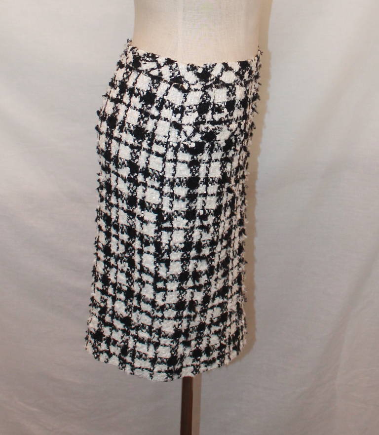 Chanel Black & White Tweed Skirt - 42. This skirt is in excellent condition and has mini-sequins adorning it. It is from 2005.

Measurements:
Waist- 28