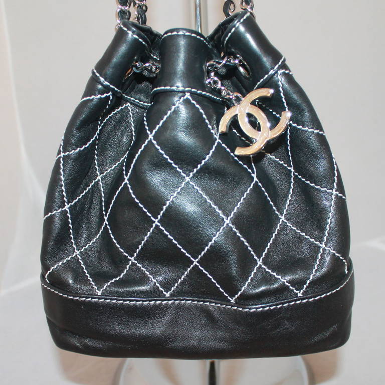 Chanel Black Lambskin Small Bucket Handbag - circa 2007. This handbag is in excellent condition with SHW and a duster. The bag has white stitching.

Measurements:
Height- 8