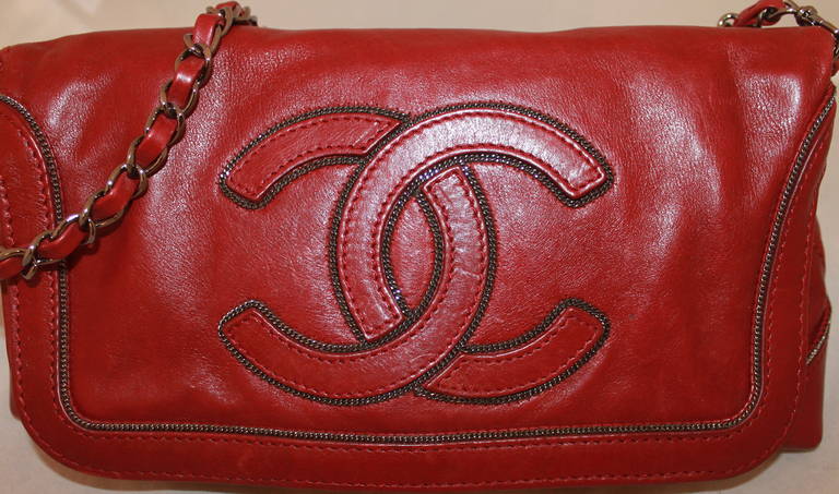 Chanel Scarlet Lambskin Shoulder Bag PHW - circa 2007. This bag is in impeccable condition with a silver chain outlining on the bag's design. It folds over and clasps shut. 

Measurements:
Height- 6.5