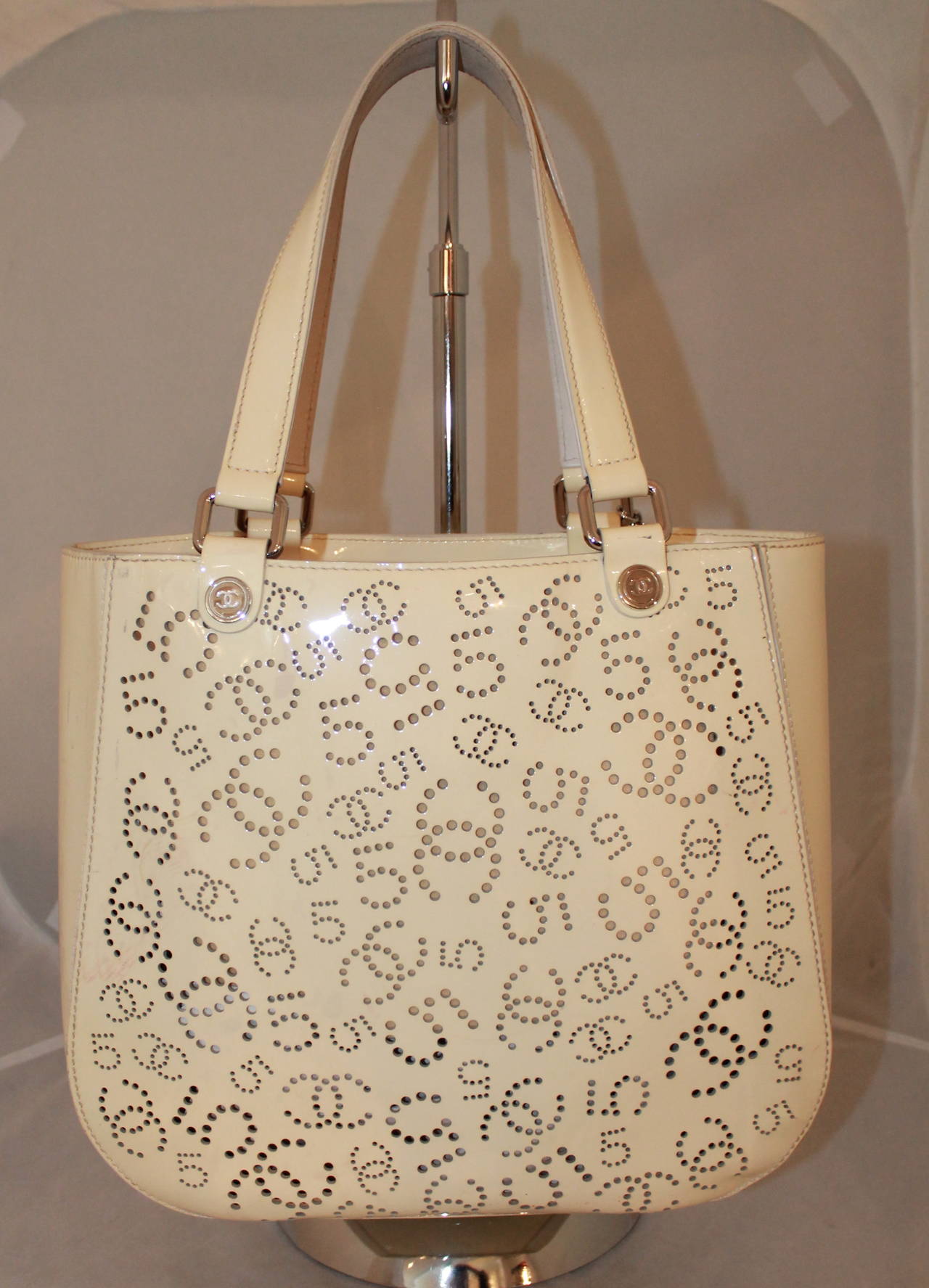 Chanel Ivory Perforated Patent Tote. This tote is in good condition with noticeable markings on the sides of the bag. It comes with an authenticity card.

Measurements:
Length- 11.5