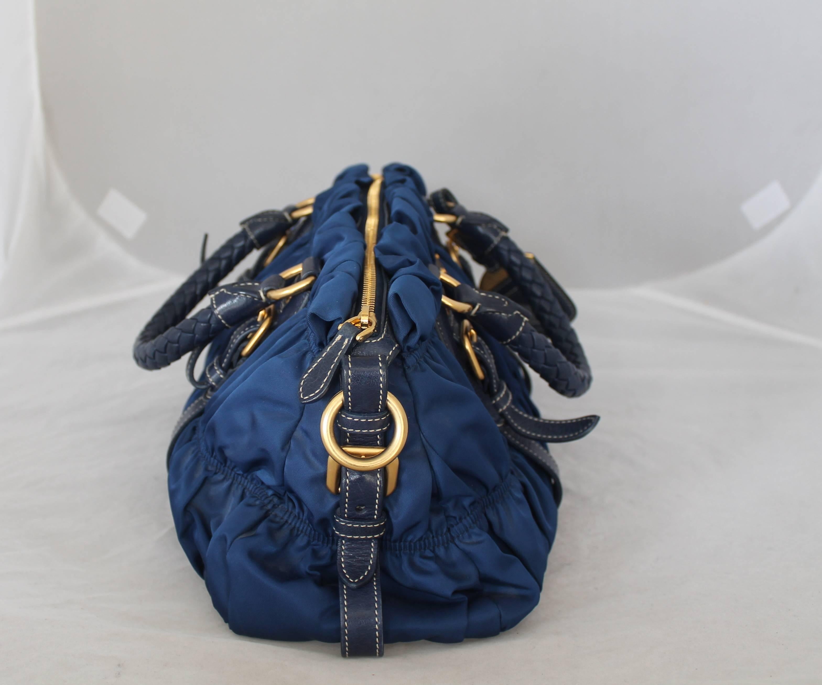 Prada Blue Nylon & Leather Ruched Bag w/ Braided Handle - GHW.  This bag is in excellent condition.  It is ruched nylon with a leather trim and a braided leather handle.  It comes with a longer strap and top handle.

Measurements:
Height: