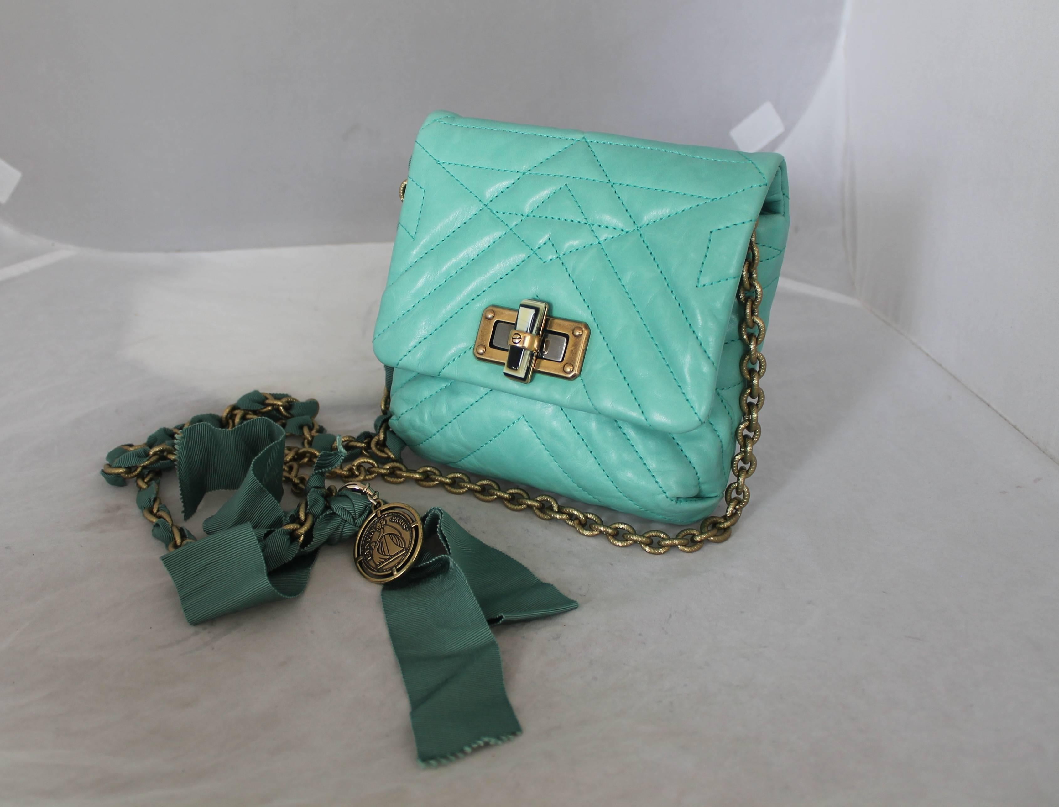 Lanvin Aqua Happy Mini Pop Crossbody Handbag - GHW. This bag is in very good condition with light wear with the only slight issue being on the inside of the bag on the leather as seen in image 3. The chain is a dull gold that is etched and is woven