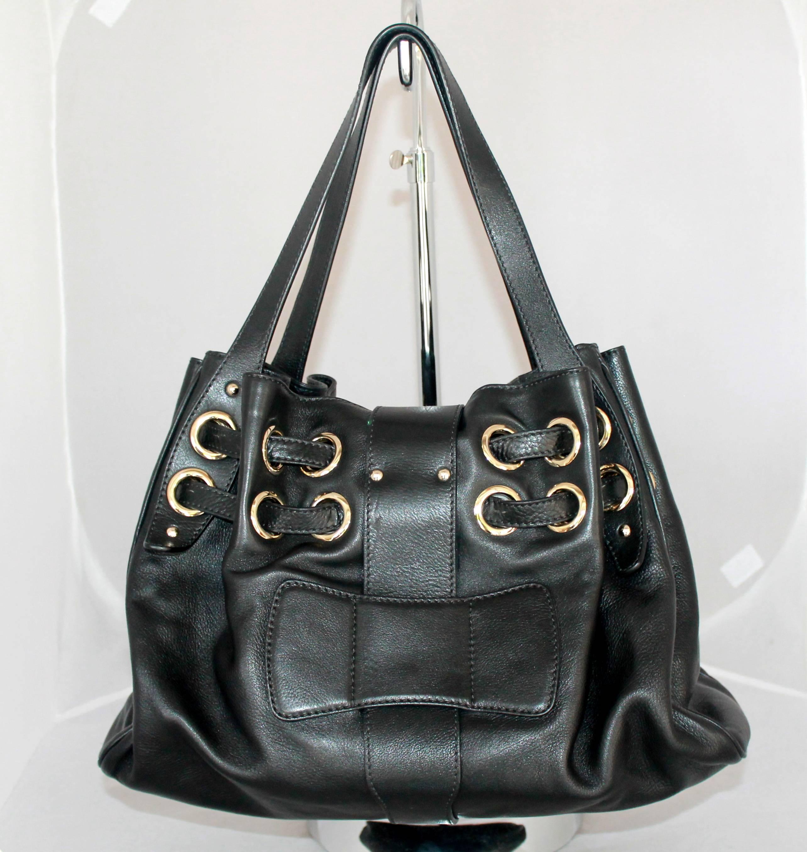Jimmy Choo Black Leather Ramona Handbag - GHW.  This beautiful handbag is in excellent condition.  It has light gold hardware, and grommets with leather woven through.  It has tan suede lining in the interior.

Measurements:
Height: 10
