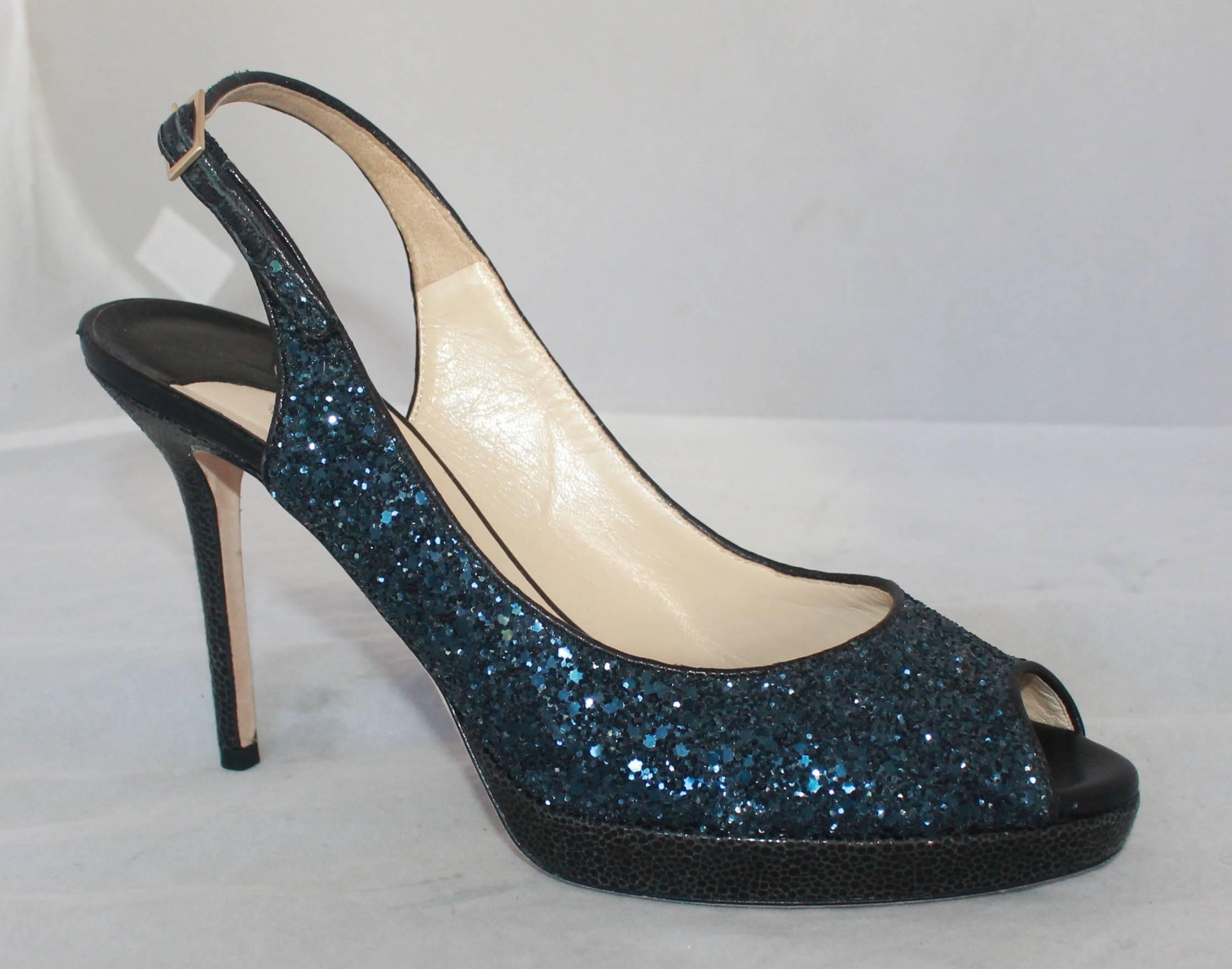 Jimmy Choo Navy Glitter Peep Toe Slingback Heels - 40

These heels are in excellent condition but do have very minor bottom wear. They are covered in navy glitter and have a cracked-style fabric on the heel. These shoes also have a matching clutch