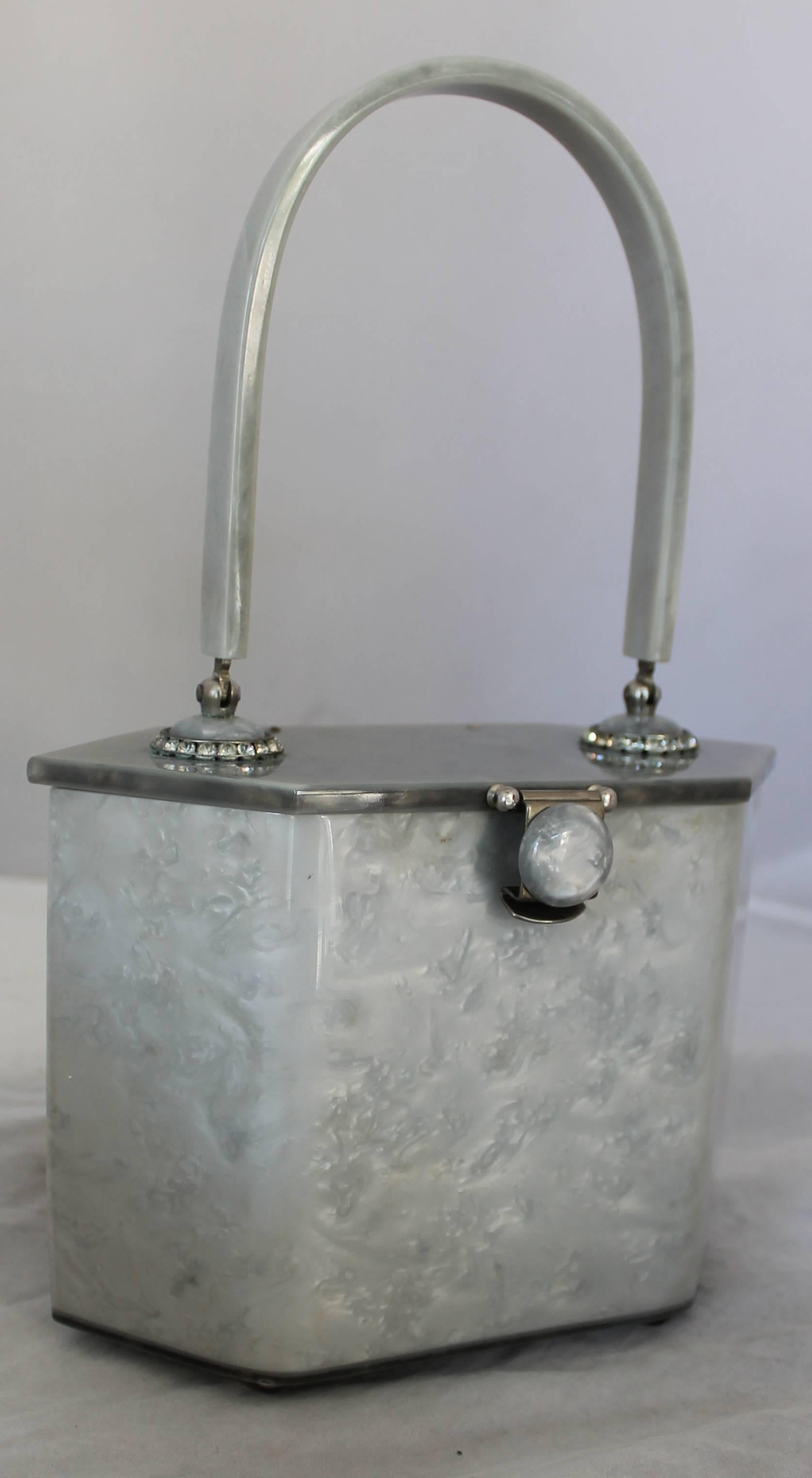 Rialto NY 1950's Grey Lucite Hexagon Top Handle Handbag.  The handle has a rhinestone detail around the bottom where it attaches to the top of the handbag. This adorable vintage bag is in good condition with only a mirror attached to the inside of