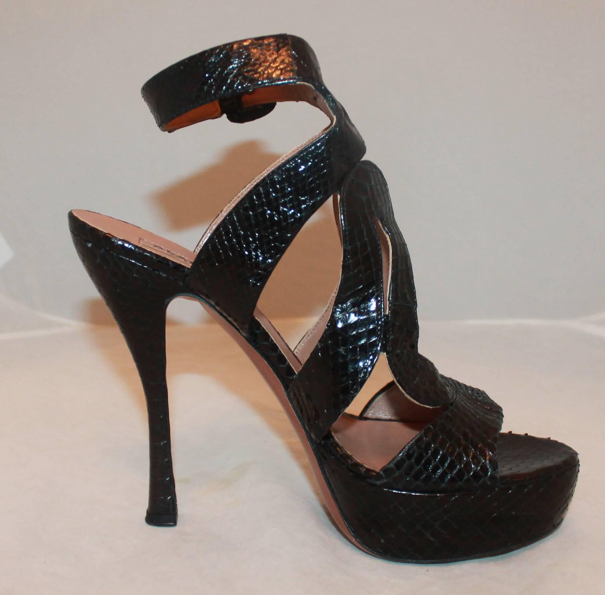 Alaia Black Plaform Cutout Snakeskin Heel - 40

These Alaia heels are in very good condition with noticeable wear on bottom. These are snakeskin cutout platform heels with an ankle strap. 

Measurements:

Heel - 5.25