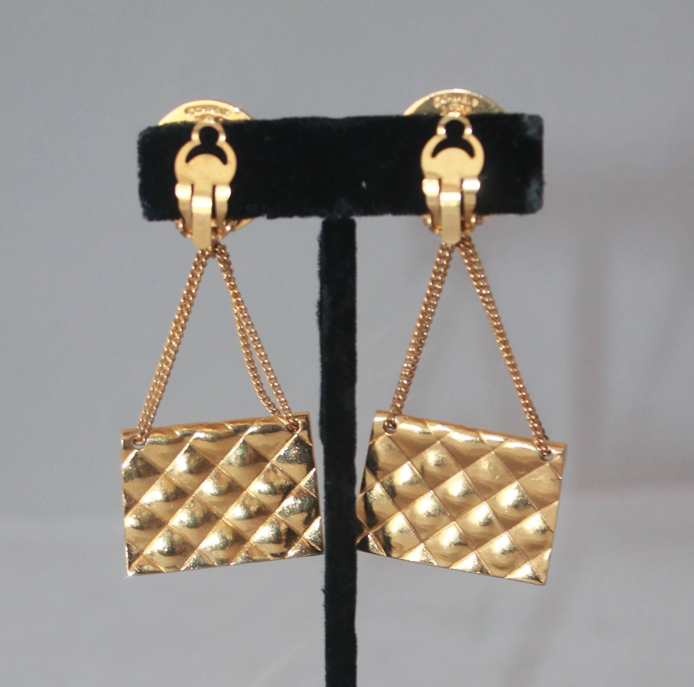 Chanel 1989 Vintage Goldtone Handbag Clip-On Earrings. These earrings are in excellent vintage condition and feature a quilted Chanel Handbag with a Chanel medallion on the top. 

Measurements:
Length- 3