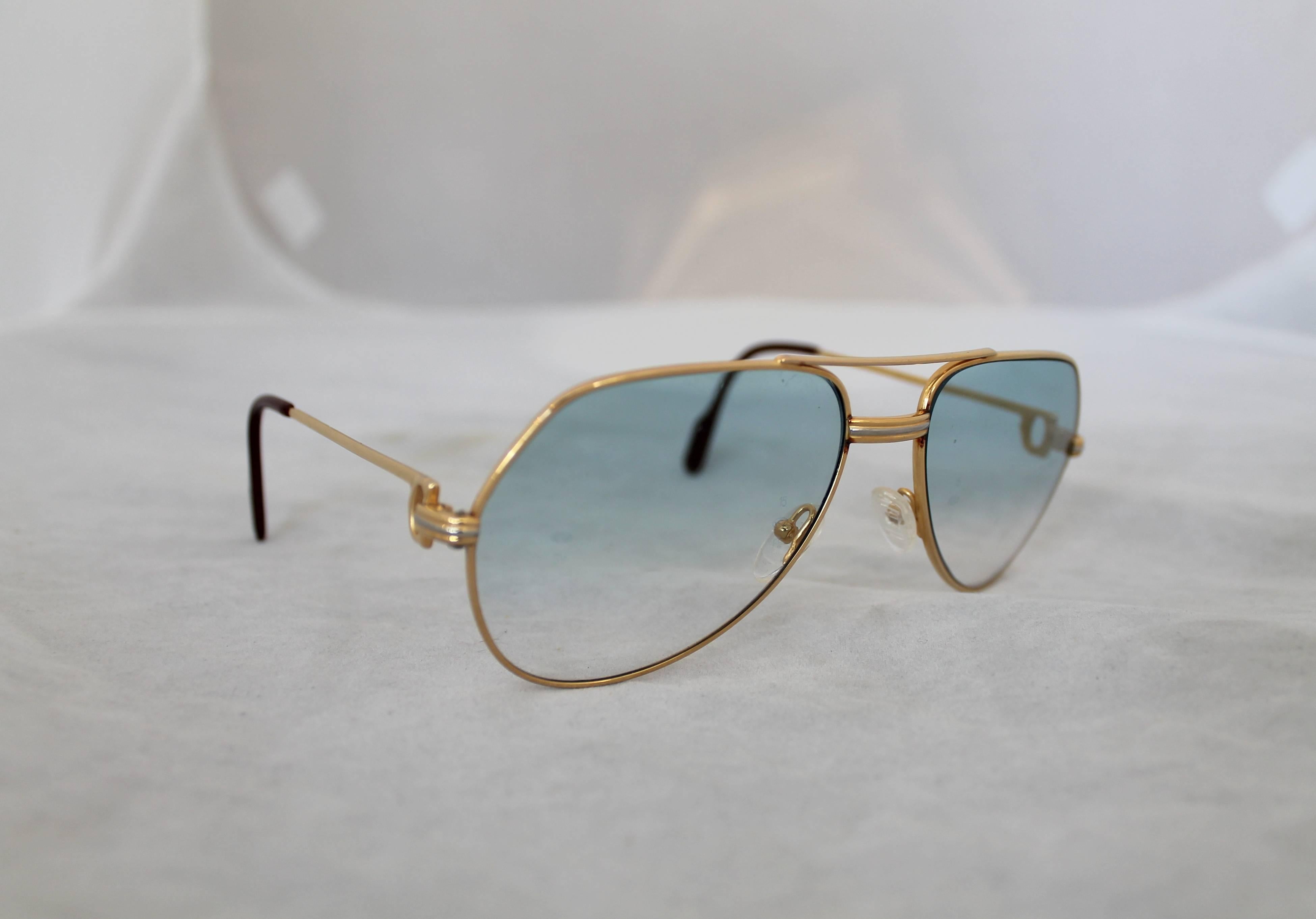 Cartier Gold Rimmed Aviator-Style Sunglasses w/ Blue Faded Lenses.  These beautiful sunglasses are in excellent condition.  They feature gold rims, rims fading from darker to lighter blue, an aviator-style, and they come with a soft, red Cartier