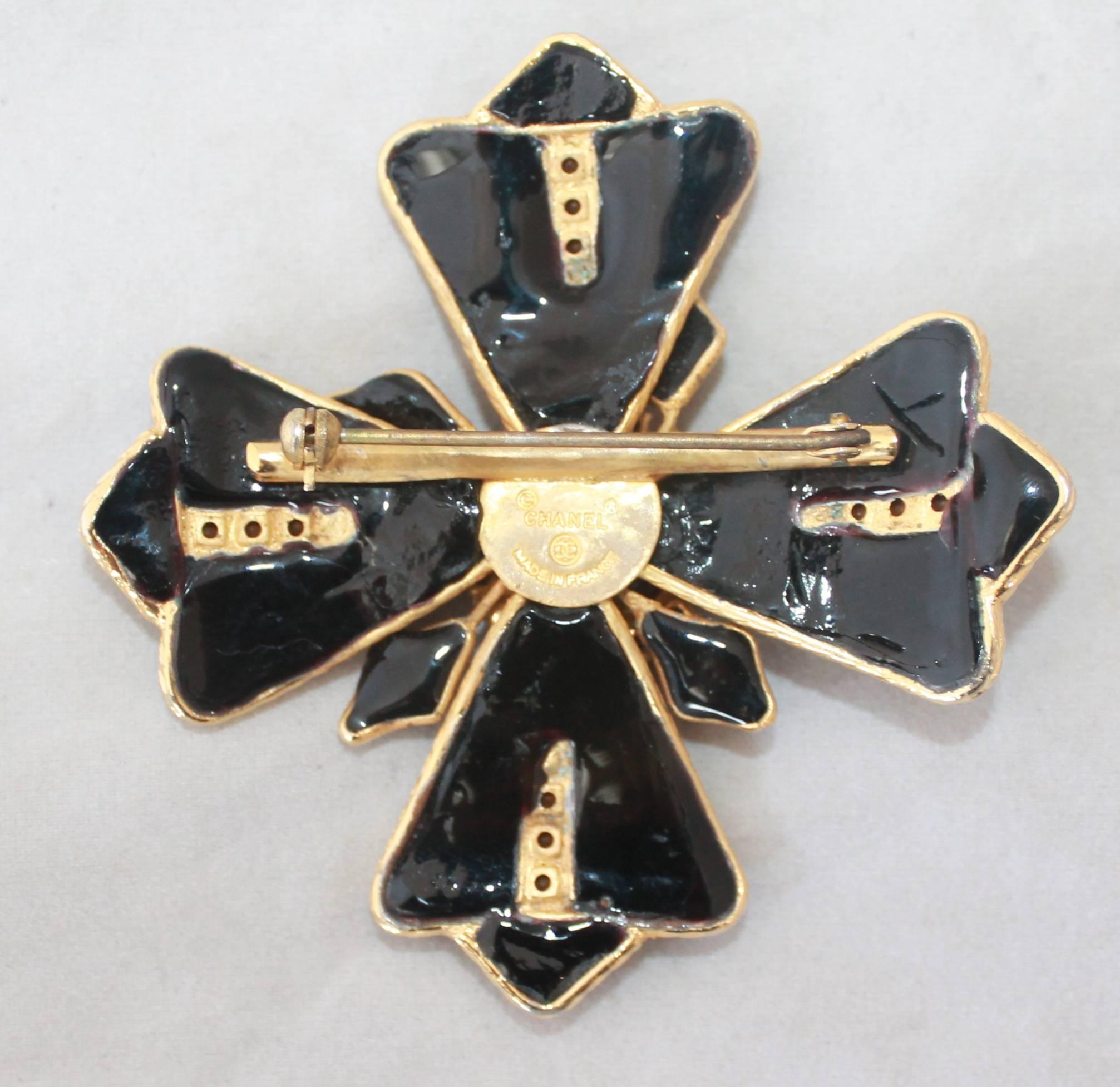 Chanel 1970's Goldtone Black Maltese Brooch Cross with Rhinestones. This piece is in excellent condition and is one of a kind. It has black enamel & a goldtone color. It is in excellent vintage condition. 

Measurements:
Length & Width- 2.75 x