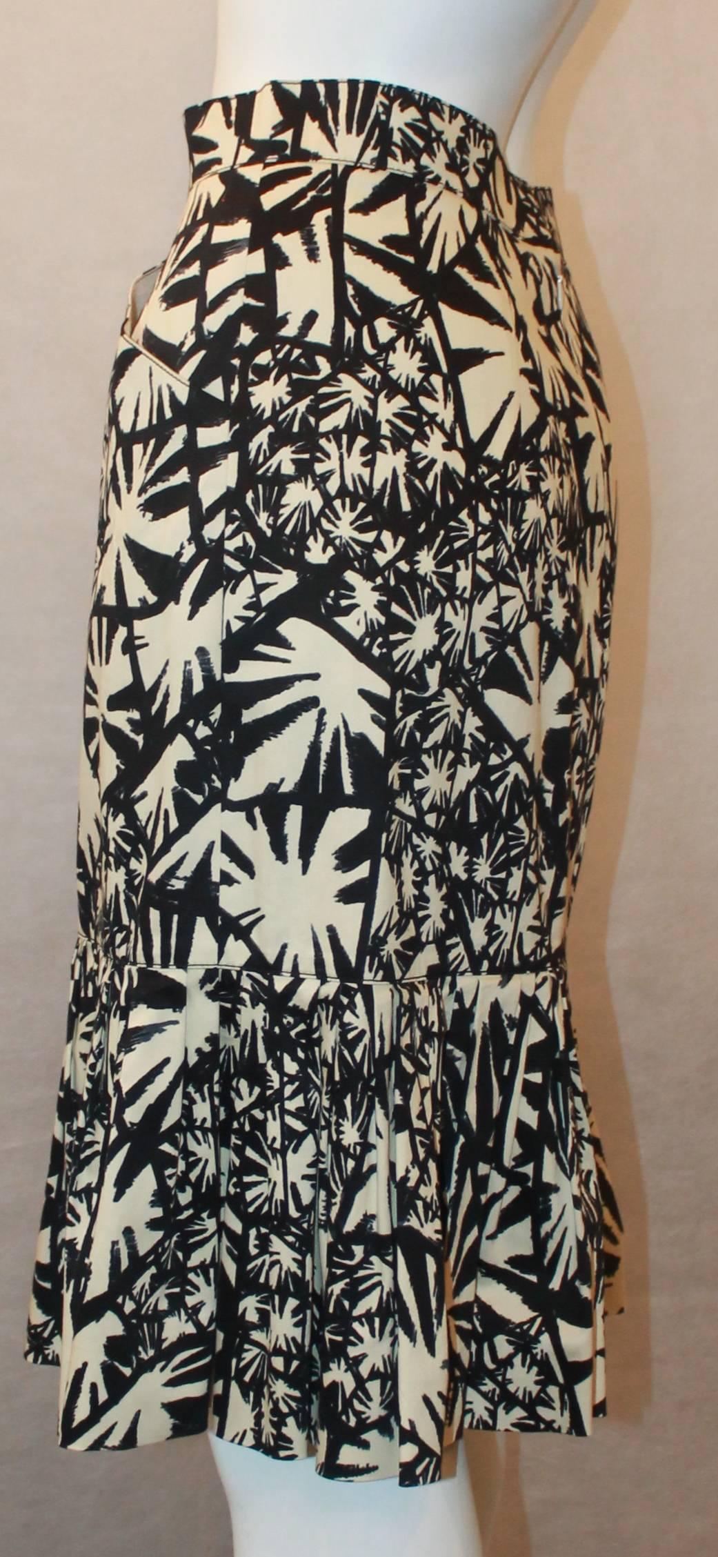 Oscar de la Renta Black & Ivory Abstract Printed Cotton Skirt - 8. This skirt is in excellent condition and has 2 side pockets. It has a panel all the way down on the front and has pleating on the bottom all the way around. It also has a back