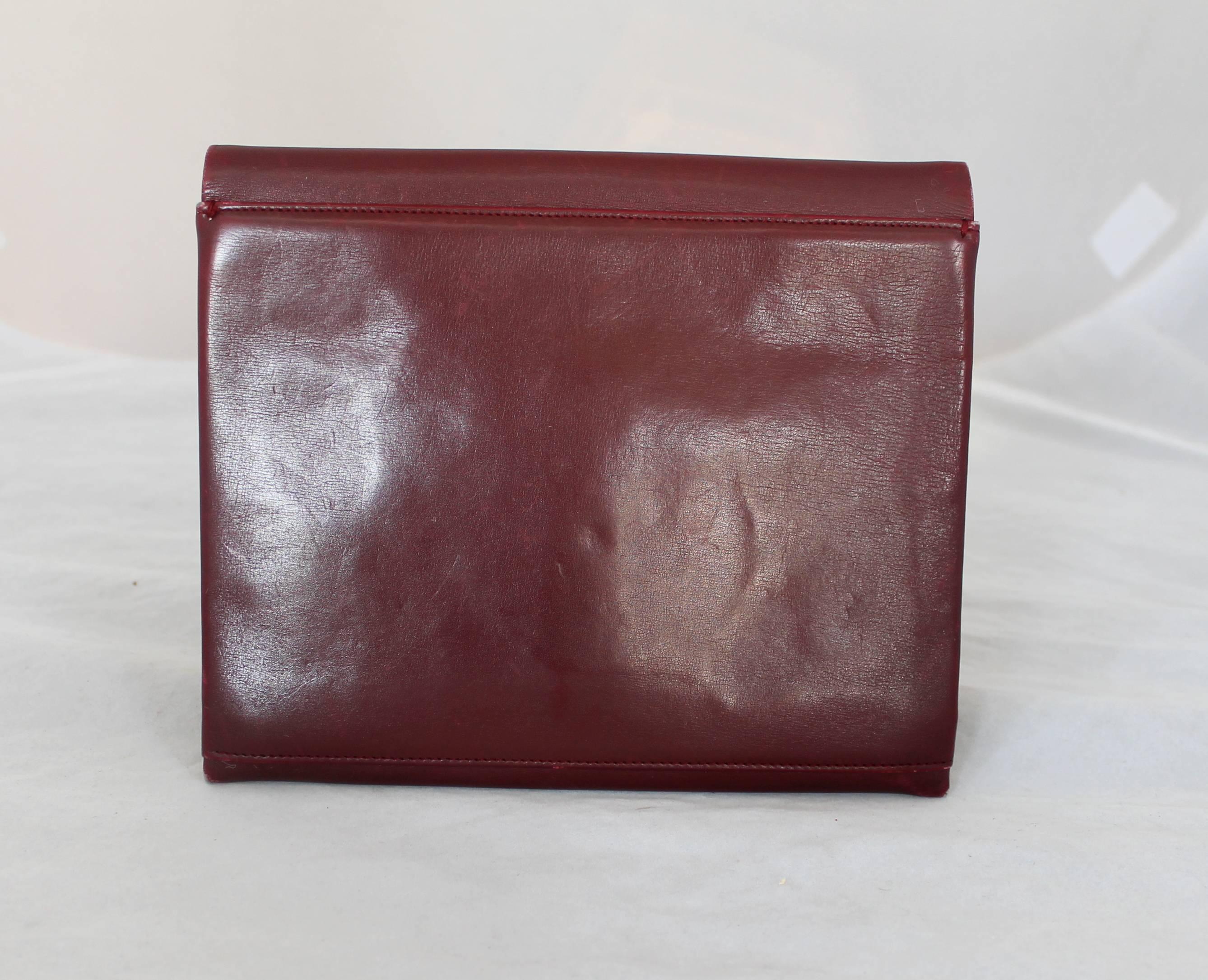 Christian Dior Vintage Burgundy Leather Clutch with Bow - circa 1990's. This bag is in fair good vintage condition with some scratches in the front and back of the bag. The piece has a red lining and a square shape. 

Measurements:
Height-