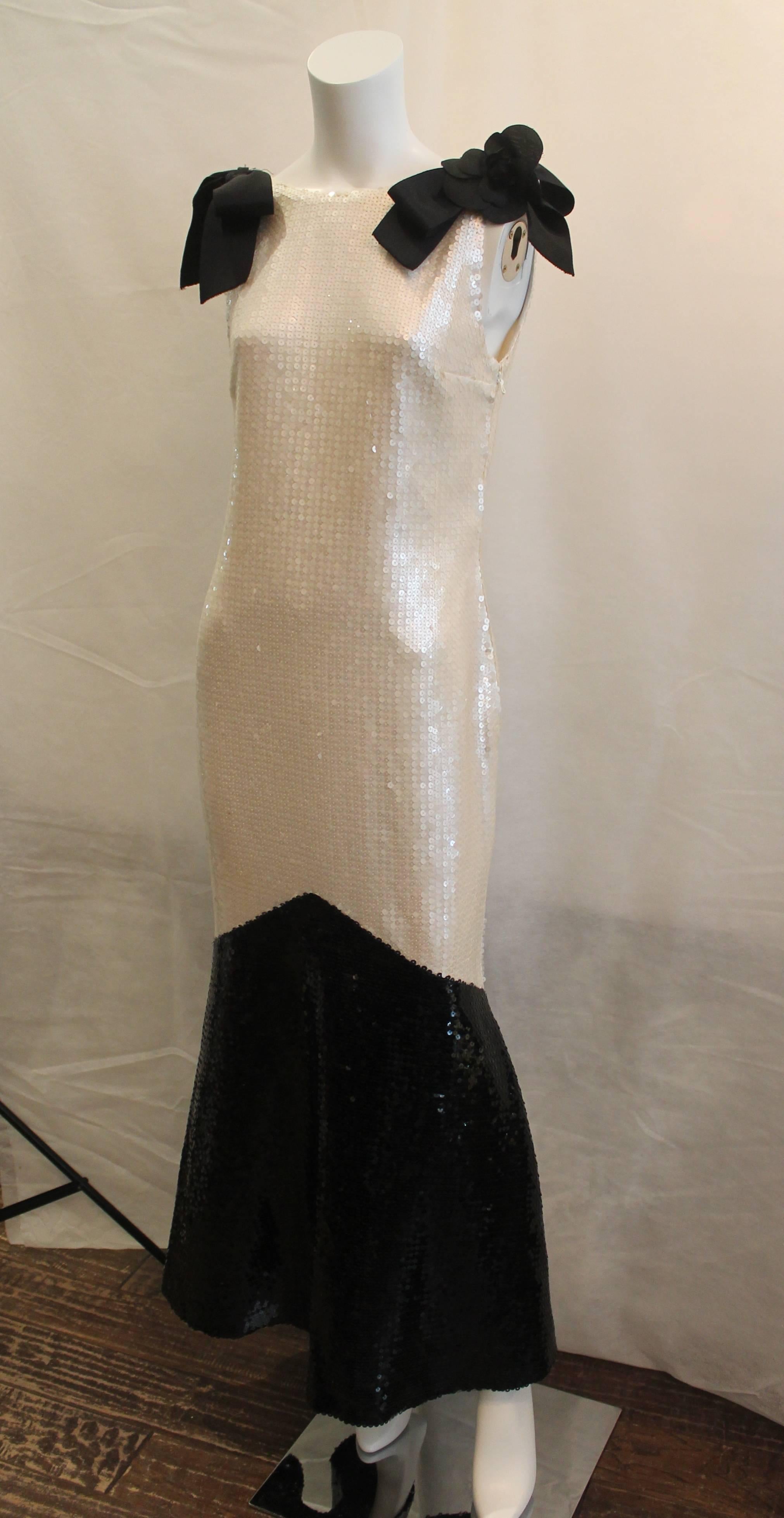 Chanel 1980's Vintage White & Black Sequin Gown with Bows & Camellia - 42. This piece is in excellent vintage condition and comes with a box. It is a very rare piece and is truly gorgeous. There are bows on each strap and a camellia on one.
