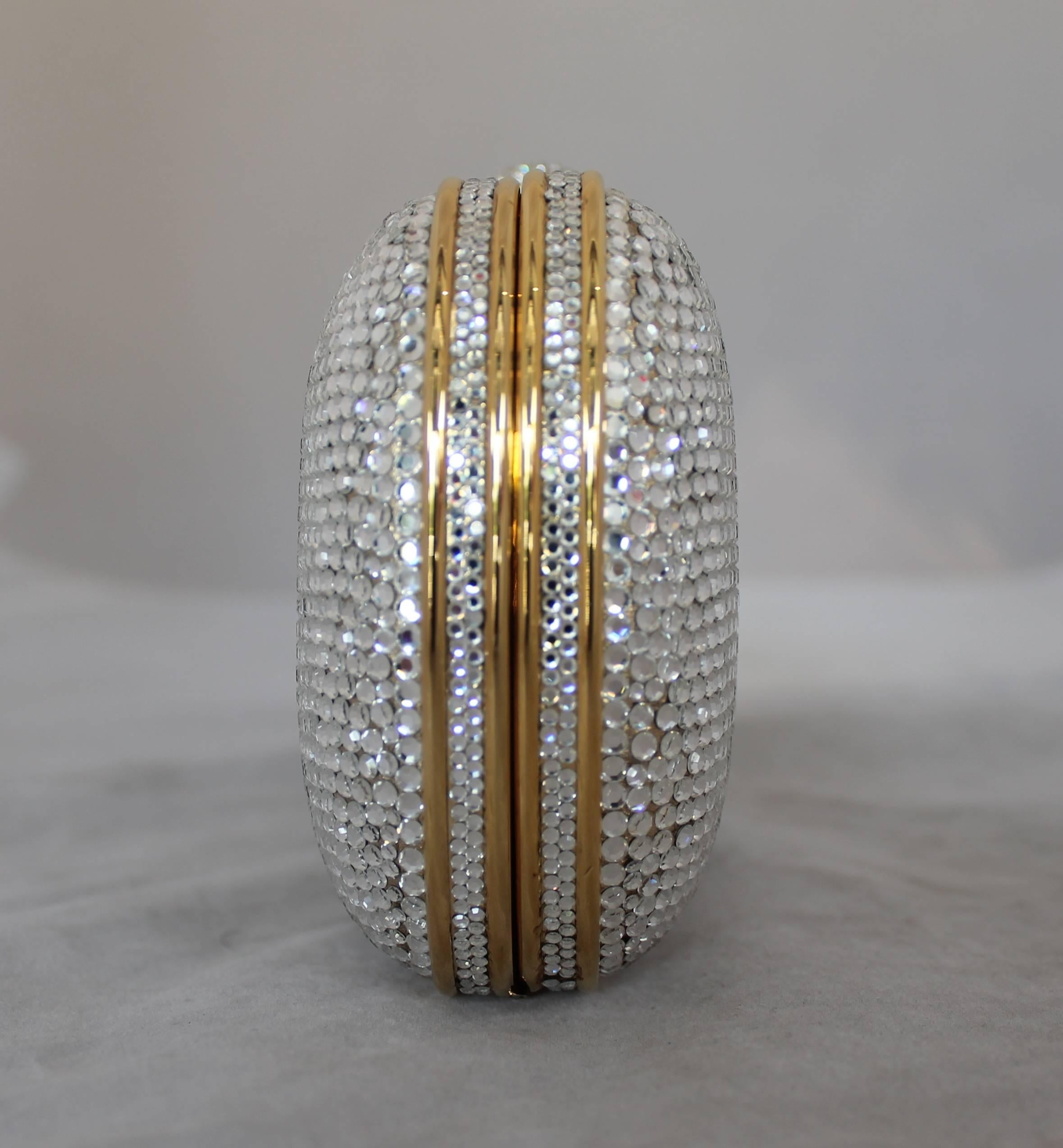 Judith Leiber Silver Rhinestone Minaudiere with Gold Strap. This bag is in excellent condition and comes with the duster, comb & mirror. It has a gold leather lining and it is a soft Leiber. It has a push clasp and can be used as a clutch or a