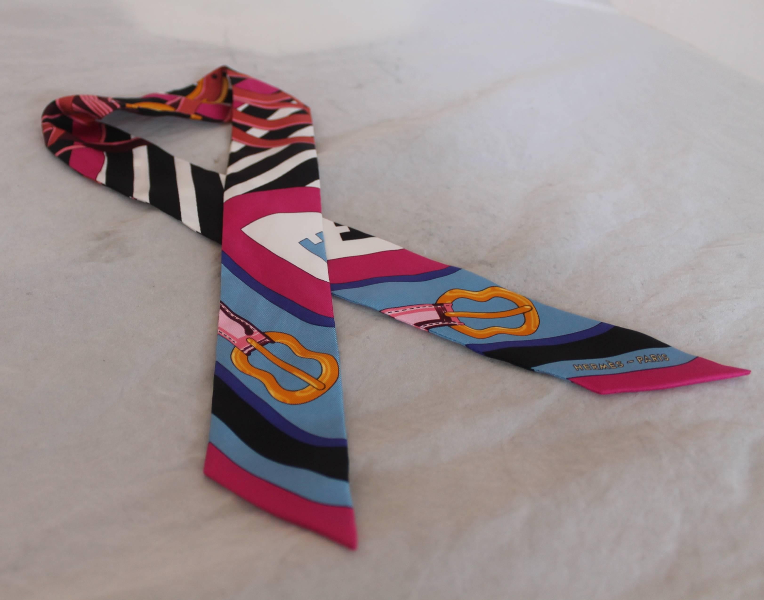 Hermes Multicolor Silk Equestrian Print Twill. This piece is in excellent condition and has black, white, blues & pinks. It has stripes and some belts on the print.

Measurements:
Length- 34.5