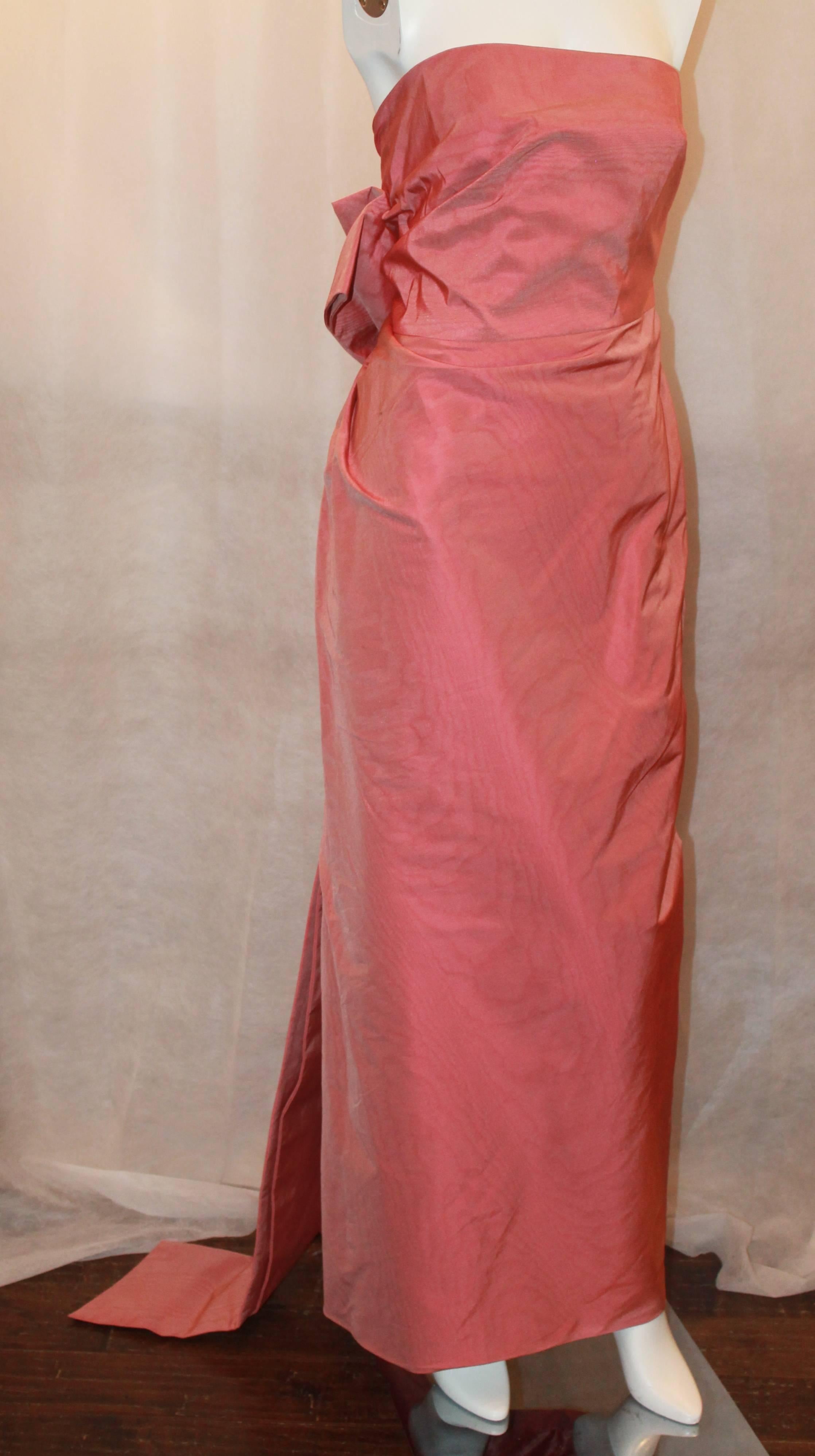 Carolina Herrera Salmon Silk Taffeta Strapless Gown w/ Ruching & Back Bow - 8 - NWT.  This lovely gown is new with tags.  It features side ruching, a floor length bow in the back, and a side zipper.

Measurements:
Bust: 30.5
