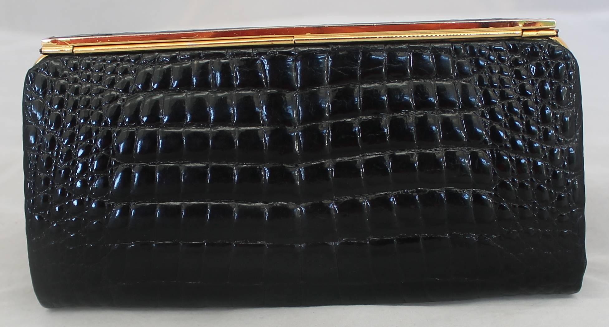 Gucci Vintage Black Small Alligator Clutch - GHW - Circa 1980's or Earlier.  This chic alligator clutch is in very good vintage condition with only some wear consistent with its age.  It features a sleek black alligator skin, gold hardware, a top