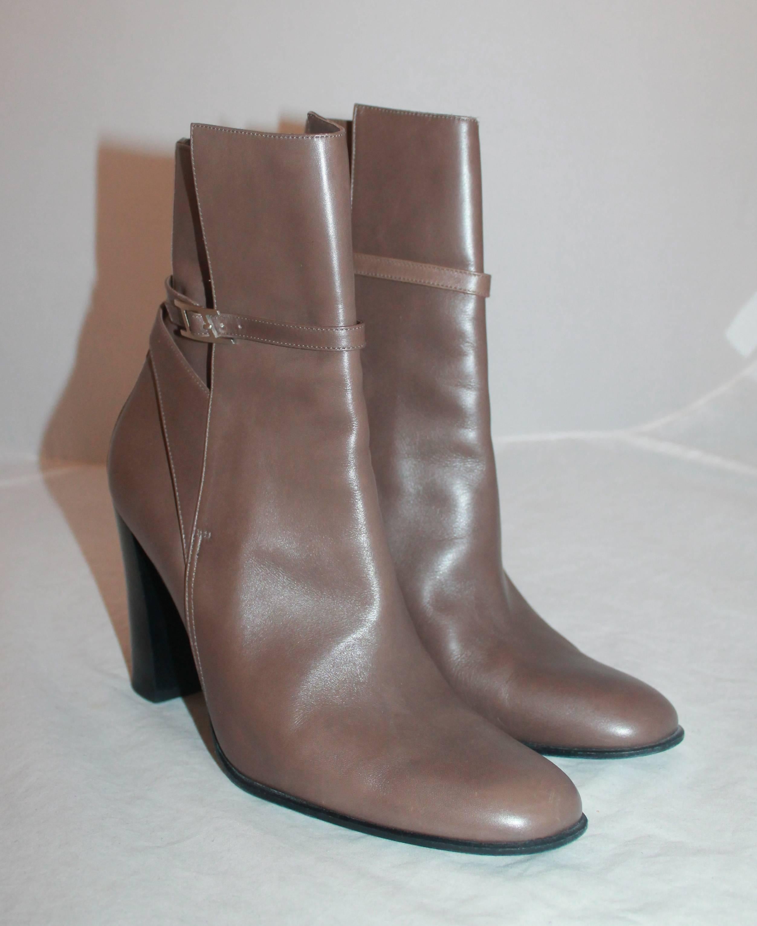Hermes Taupe Leather Heeled Boots w/ Ankle Strap & Buckle - 39.  These beautiful Hermes boots are in very good condition with a slight scuffing at the top of the left boot.  They feature a gorgeous taupe leather, a layered appearance, and an ankle