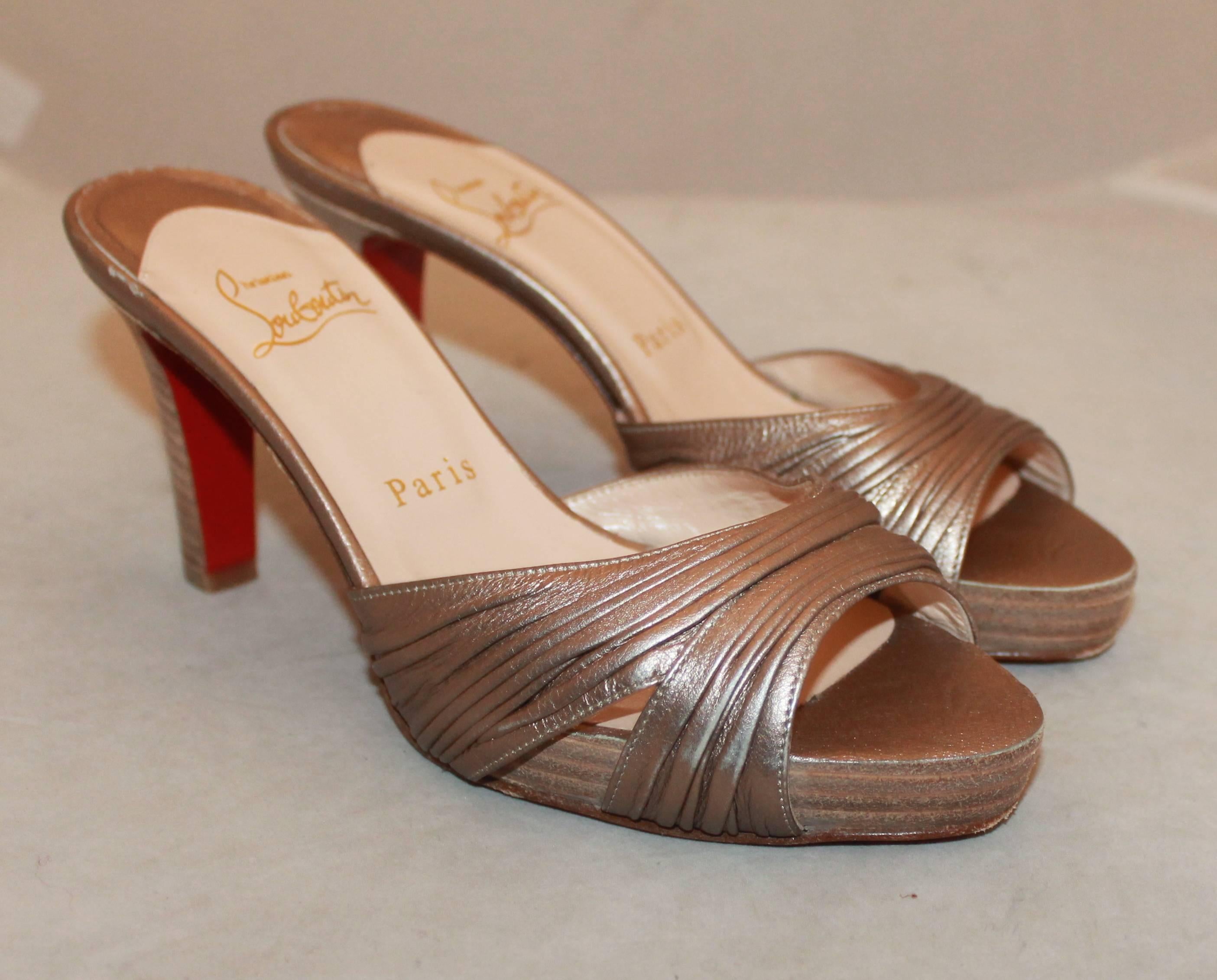 Christian Louboutin Bronze Woodstack Heel - 37.  These lovely sandal heels are in good condition with some visible wear to the bottom.  They feature a gorgeous bronze metallic look, a sandal look, and a woodstack heel.  these are excellent shoes for