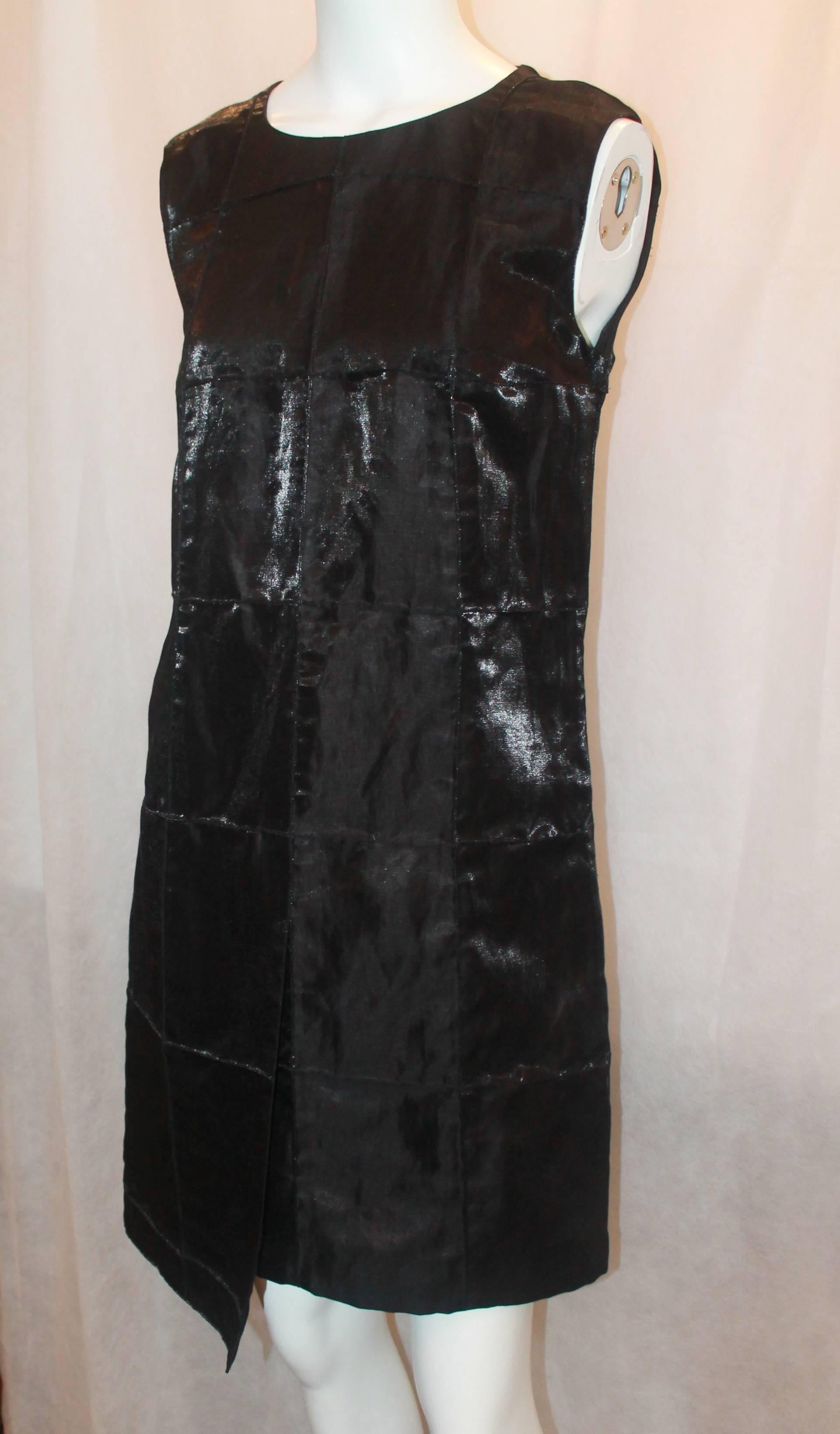Chanel Black Metallic Quilted Asymmetrical Shift Dress - 40 - 1999. This dress is in excellent condition and has a slight metallic sheen to it. The fabric on the dress looks like it is sewn together piece by piece and it has a small 