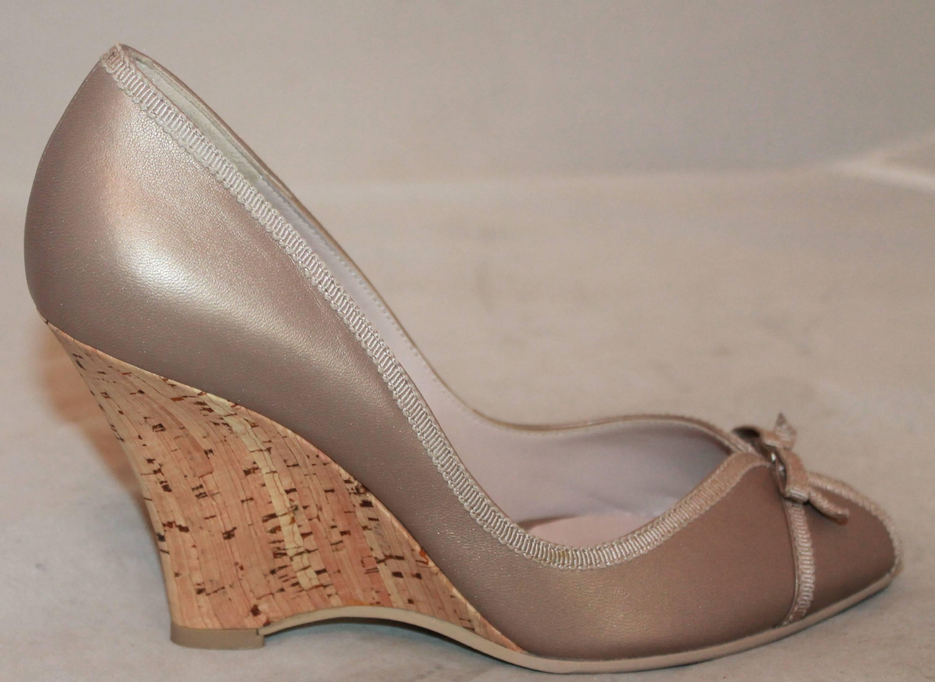 Salvatore Ferragamo Champagne Leather Peep Toe Cork Wedges - 7B.  These gorgeous shoes have never been worn.  They feature a beautiful shiny champagne leather, a grosgrain ribbon trim and bow, and a cork wedge.

Measurement:
Heel: 3.5