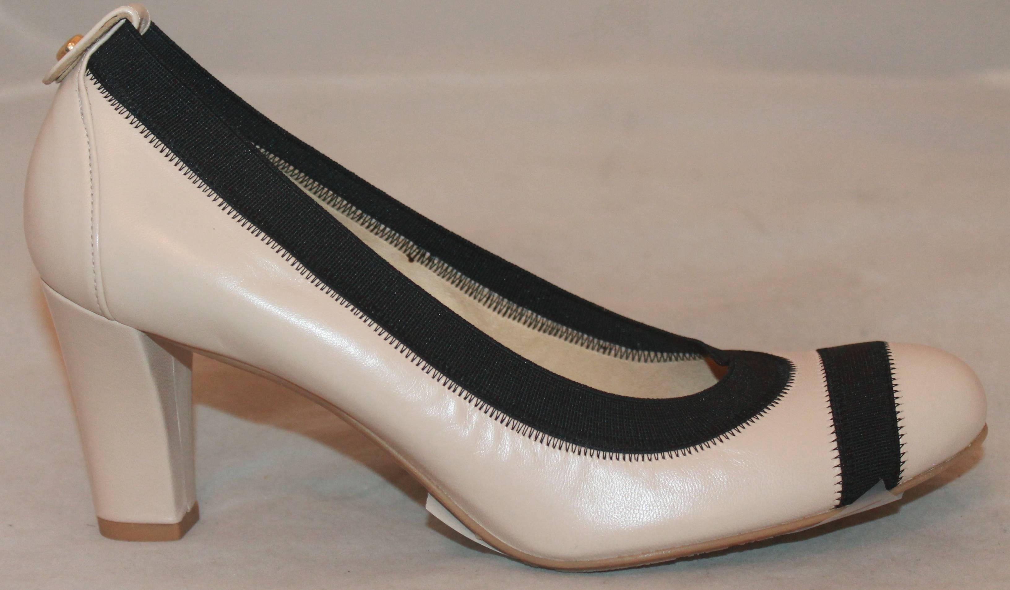 Stuart Weitzman Ivory & Black Stretch Leather Pump - 7 Narrow.  These lovely pumps have never been worn.  They feature a lovely ivory leather, black stretch band along the trim and on the toe.

Measurement:
Heel: 2.75