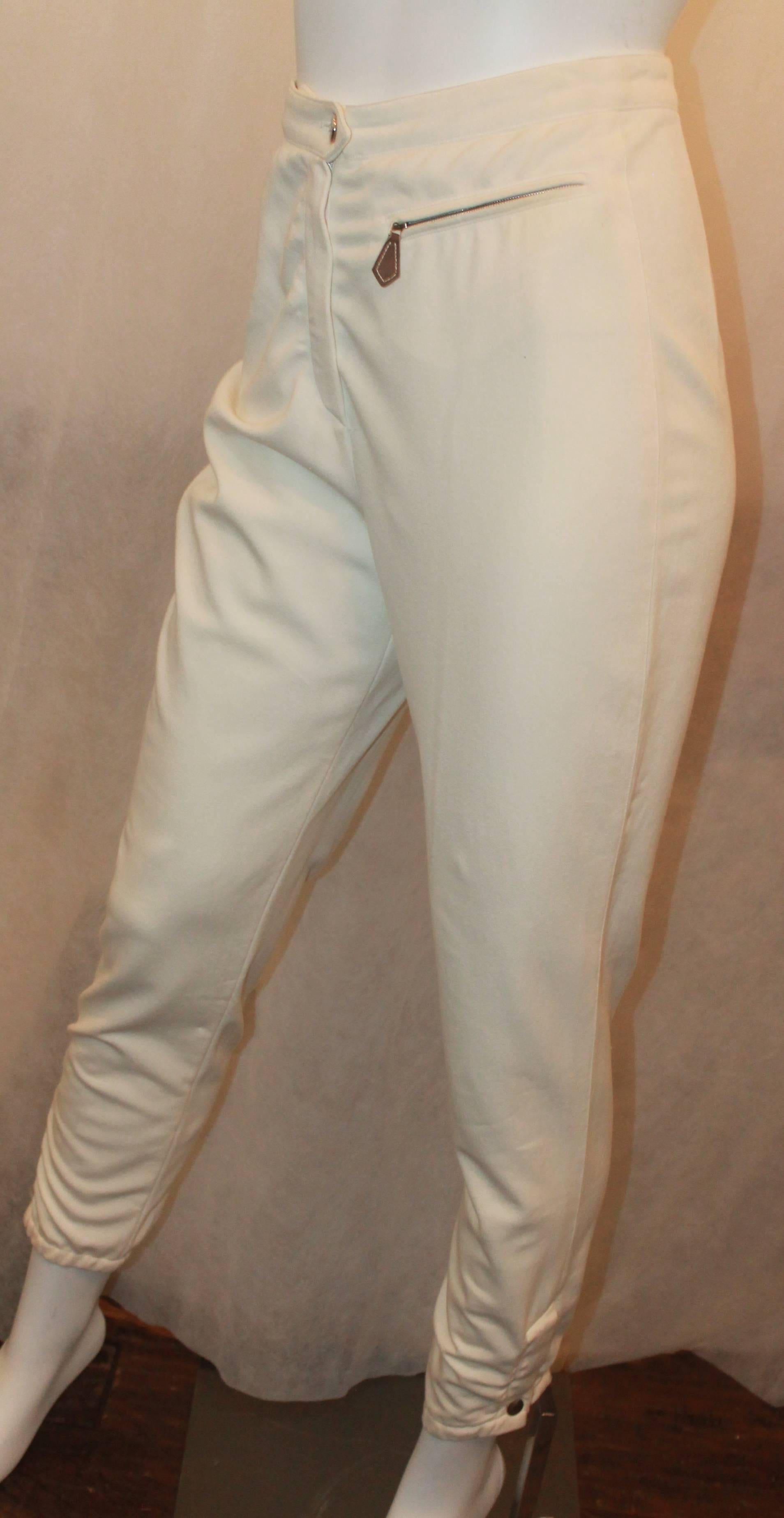 Pantalon d'équitation à taille haute Hermès Ivoire - 34 - circa 1990's. Ce pantalon est en très bon état vintage avec une usure correspondant à son âge. Ils sont dotés d'une poche zippée en cuir sur le bas. 

Mesures :
Taille - 25-26