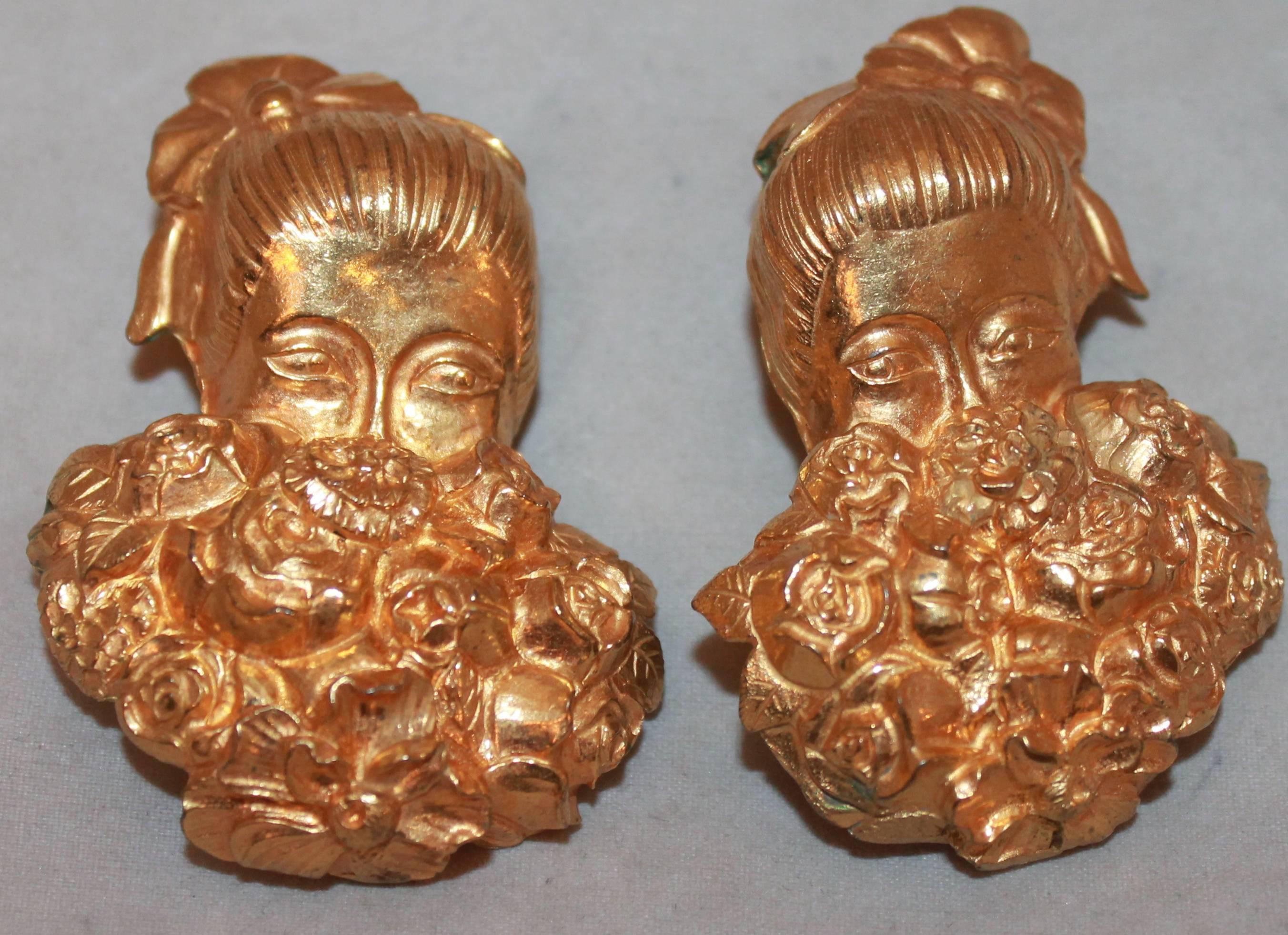 Isabel Canovas Vintage Goldtone Girl Behind Flower Bouquet Clip-On Earrings-Circa 1980's.  These earrings are in very good vintage condition with only some areas of green on the inside.  They feature a goldtone metal of a girl's face hiding behind a
