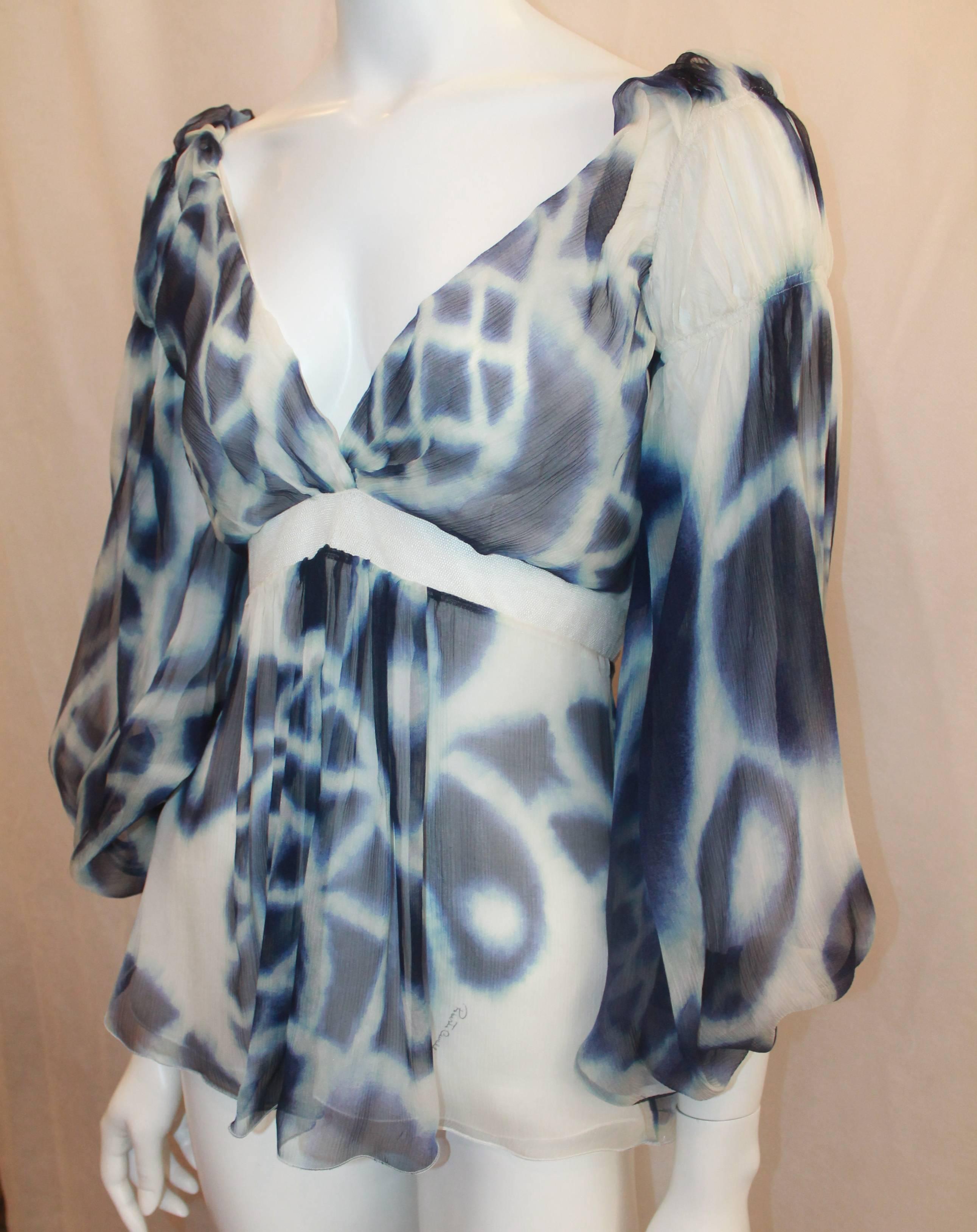  Roberto Cavalli Blue & White Printed Silk Chiffon Blouse - 38. This flowing blouse is in excellent condition and has a watercolor-like print. This top features a plunging neckline, puffy sleeves, and a mesh waist section.

Measurements:
Bust- Up