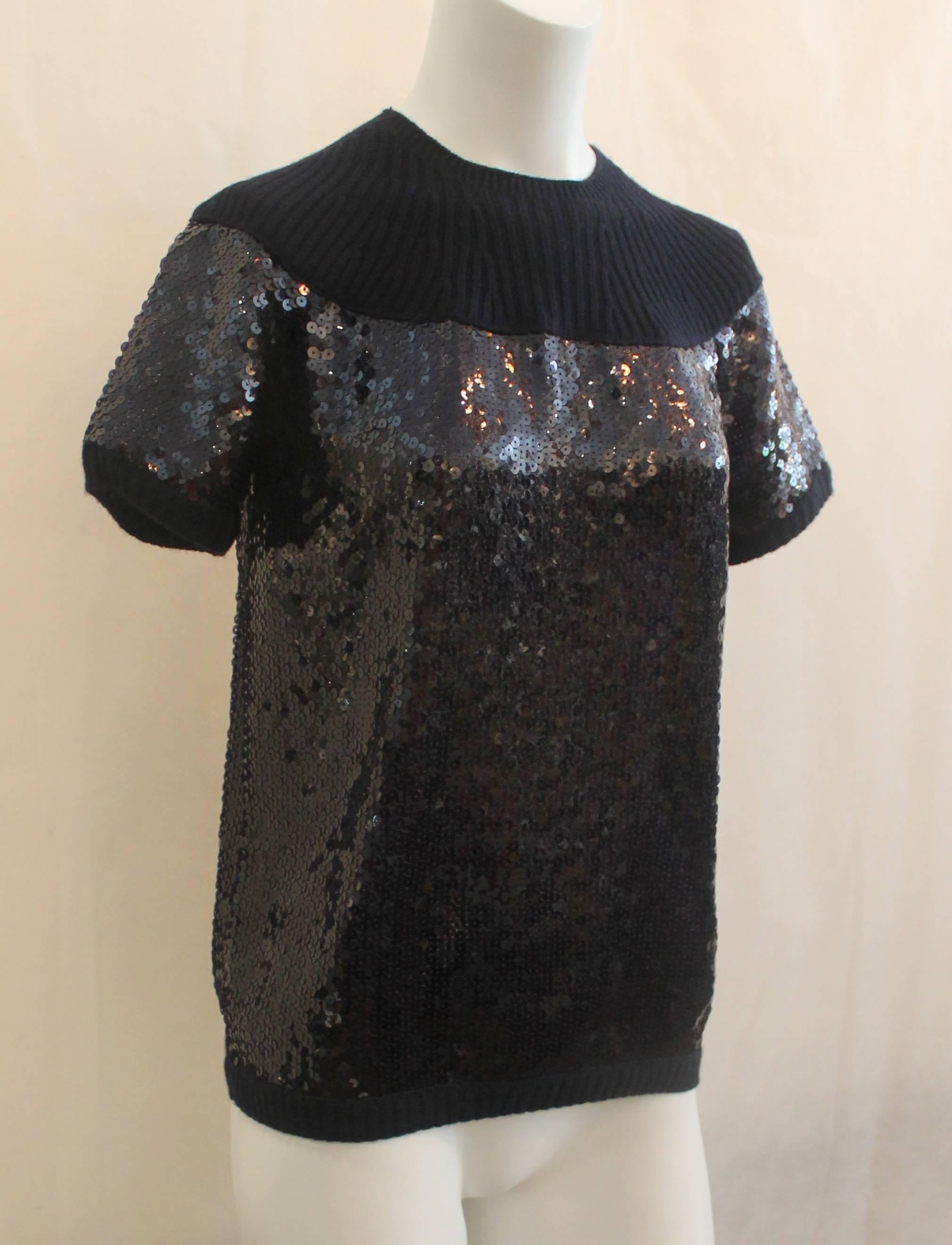 Chanel Navy Cashmere Sequin Short Sleeve Blouse - 40. This blouse is in excellent condition and is a great dressy piece. It features ribbed cashmere and a side zipper.

Measurements:
Bust- 18