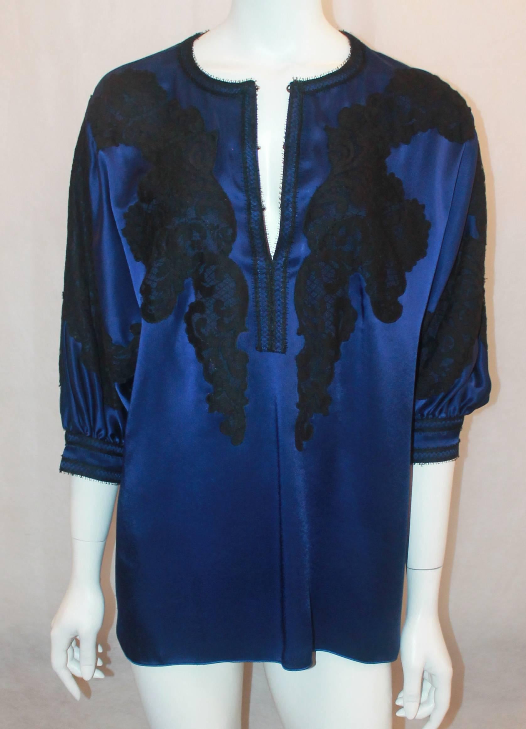 Andrew GN Blue & Black Silk Tunic Top with Lace Detail - 40. This top is good condition with some faint stains on the front on the very bottom. The blouse features 3/4 sleeves, black lace trim, and hook & eye closures on the front