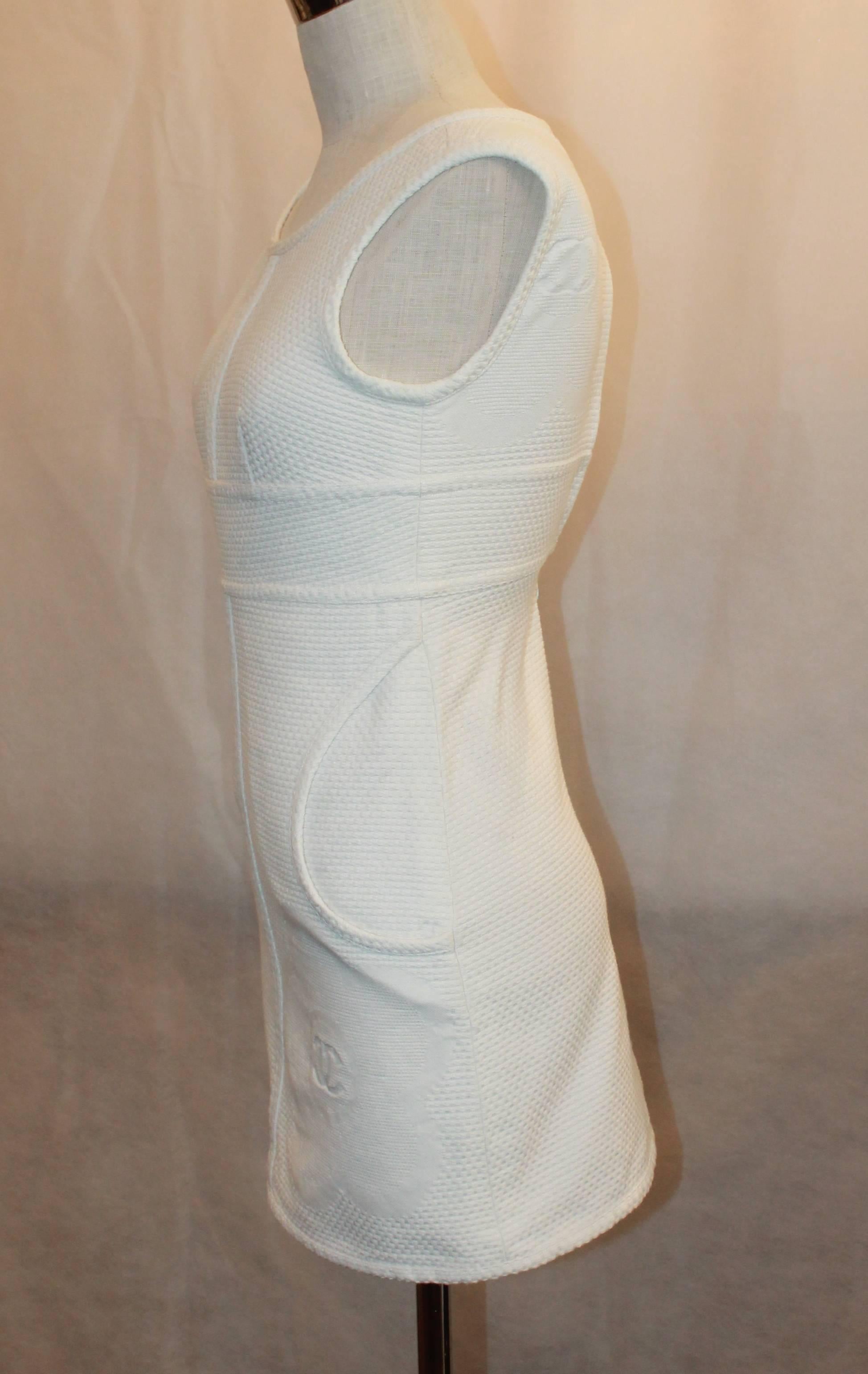 Chanel White Cotton Sleeveless Mini Dress with Pockets - 34 - 09P. This dress is in excellent condition with very little wear. The dress' fabric is textured and has a flower print on it with a 