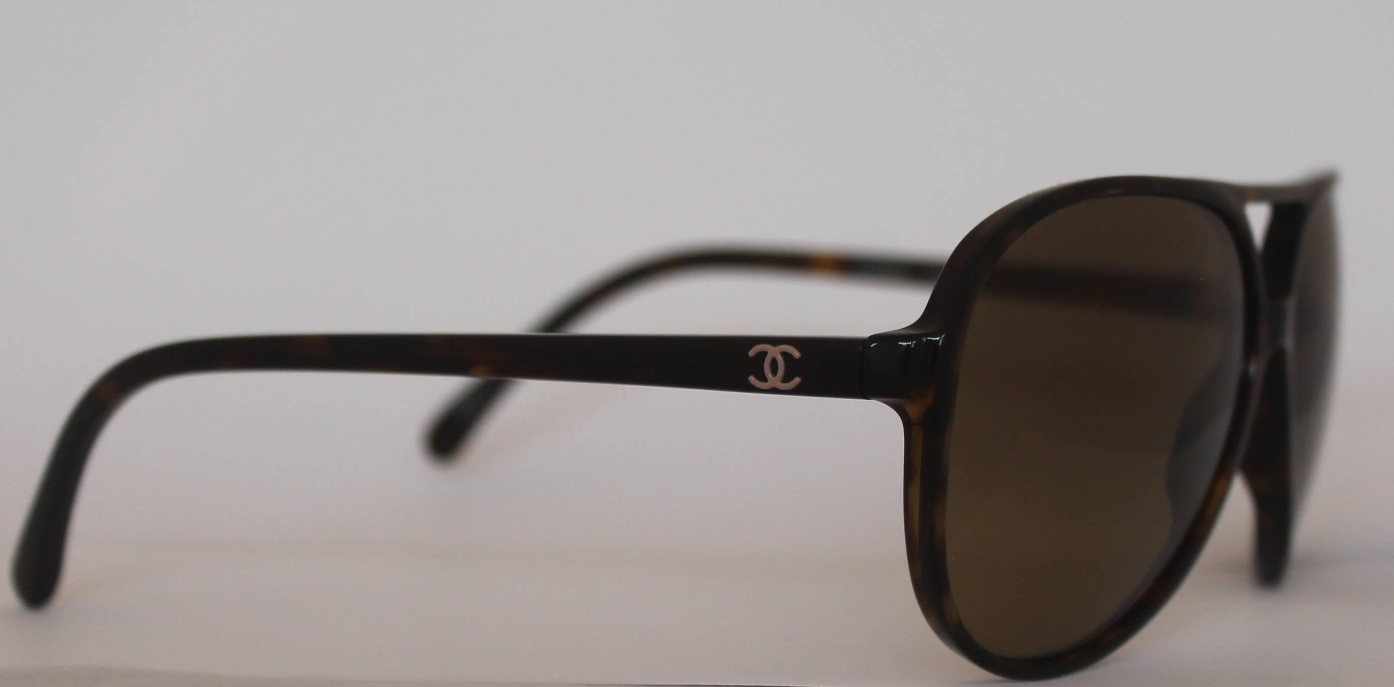 Chanel Tortoise Aviator Glitter Lens Sunglasses. These sunglasses are great for the summer. They are a tortoise color with Chanel glitter lenses. On each leg, a silver Chanel logo can be found. They are in excellent condition but the left leg is