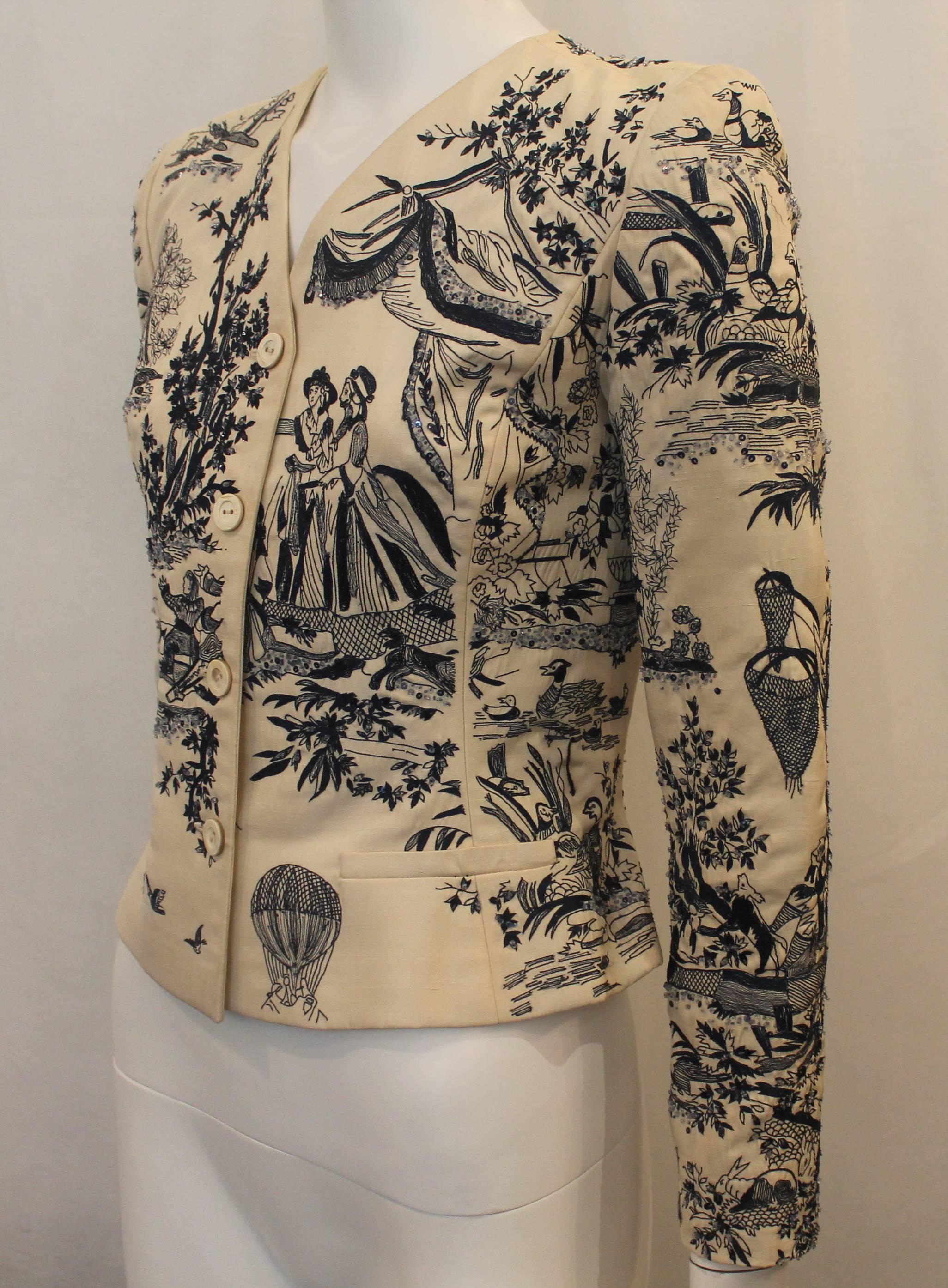 Oscar de la Renta Ivory and Navy Beaded and Sequined Jacket - 6. This jacket is ivory with two decorative pockets, buttons on the front, and embroidered images on the fabric. There is some beading and sequined detailing. This jacket is in good