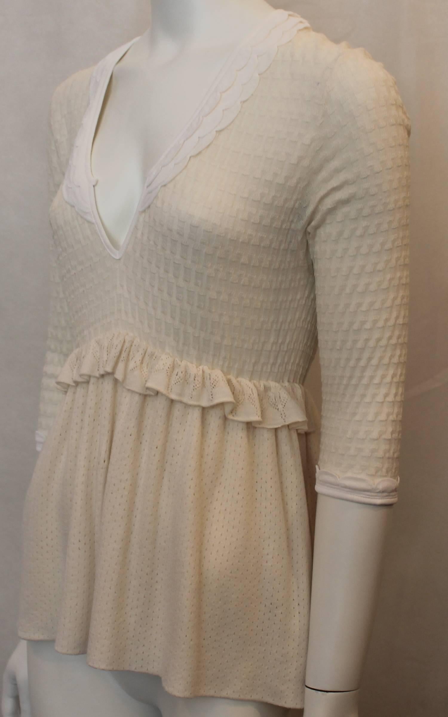 Fendi Ivory & White Knit 3/4 Sleeve Babydoll Top - 44. This top is in excellent condition and features a textured knit fabric with a slight middle ruffle, deep v-neck, and a triple ruffle at the neckline.

Measurements:
Bust- up to 40