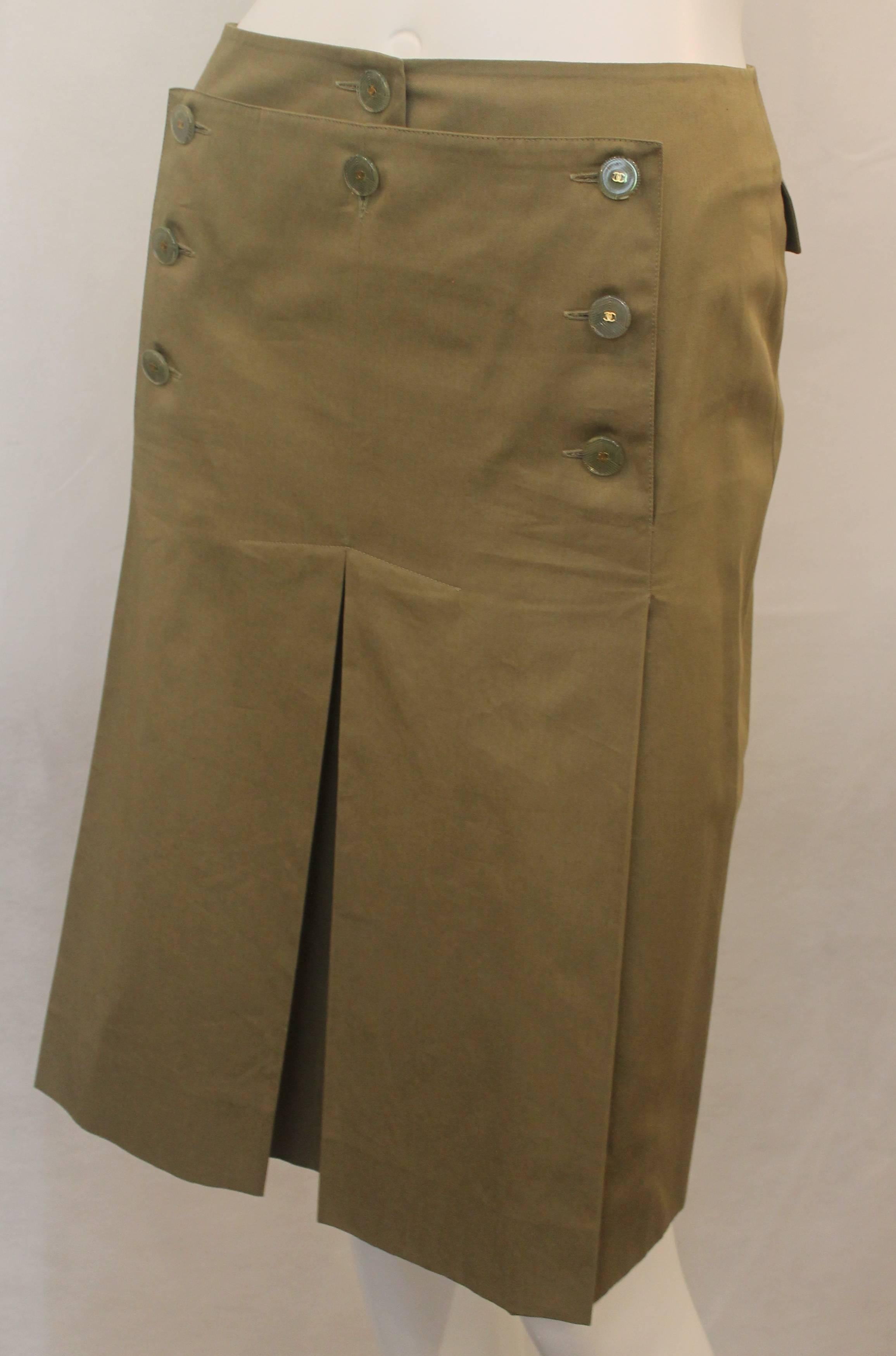 Chanel Olive Skirt with Pleating and Lucite Buttons - 36 - 02 P. This beautiful skirt is green with pleating. There are 2 big front pleats and 2 pockets in the back. The buttons are Lucite with a gold 