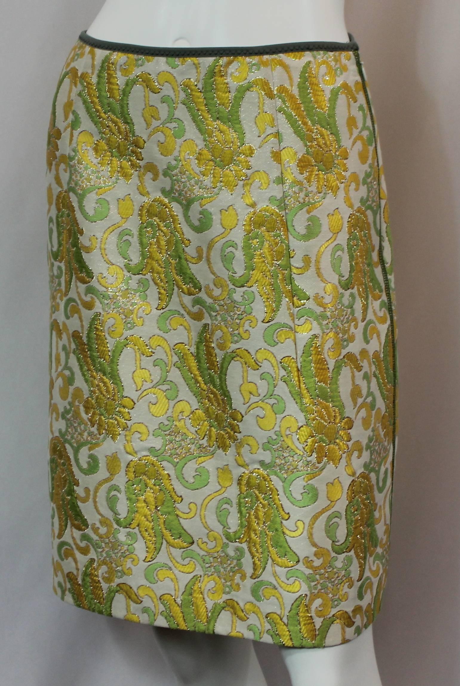 Prada Silk Blend Multi-Colored Printed Brocade Skirt - 40. This beautiful yellow, green, and ivory printed brocade skirt has gold stitching and olive trim on the waist. It also has a side zipper and is in excellent condition.

Measurements: