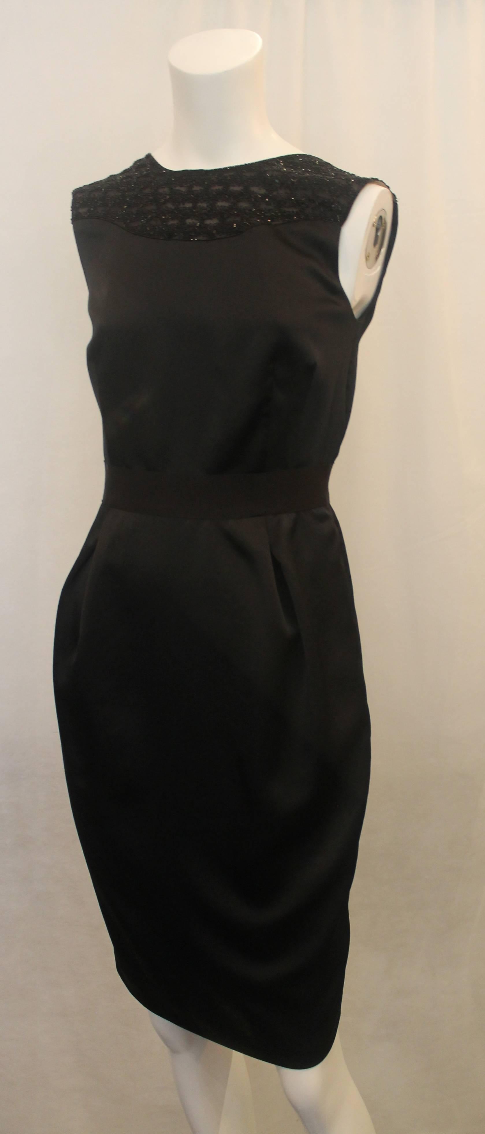 Valentino Black Sleeveless Tapered Dress with Beading Silk Dress - S. This beautiful sleeveless dress is tapered, has 2 front pleats, and a grosgrain ribbon by the waist. The upper back has an open v-shape. The neckline is sheer fabric with beading.