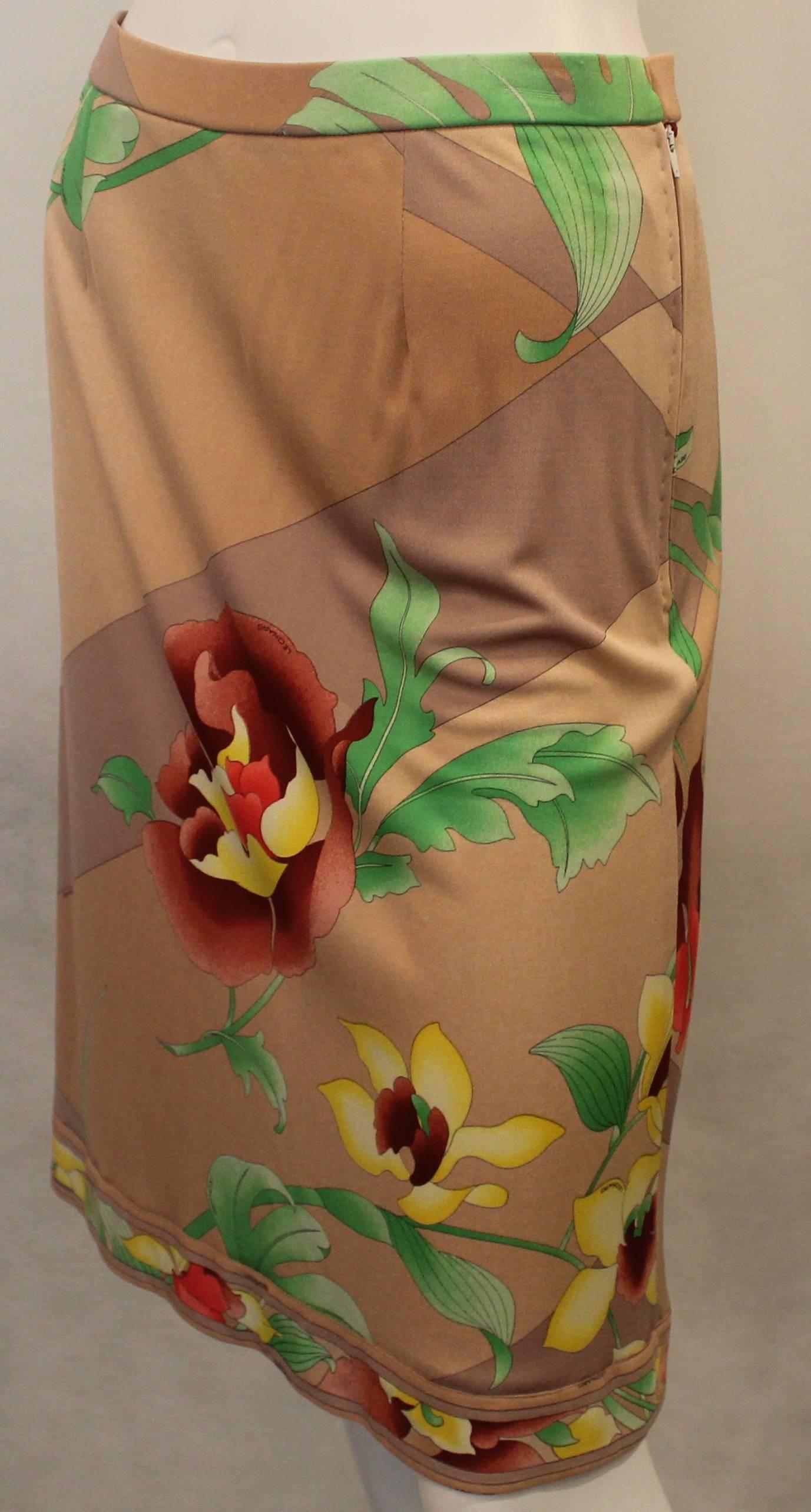 Leonard Tan Silk Jersey Skirt with Large Floral Print - 38. This skirt is in good condition with small pulls throughout and wear being consistent with age. The skirt features a waist band, side zipper, and printed trim on the