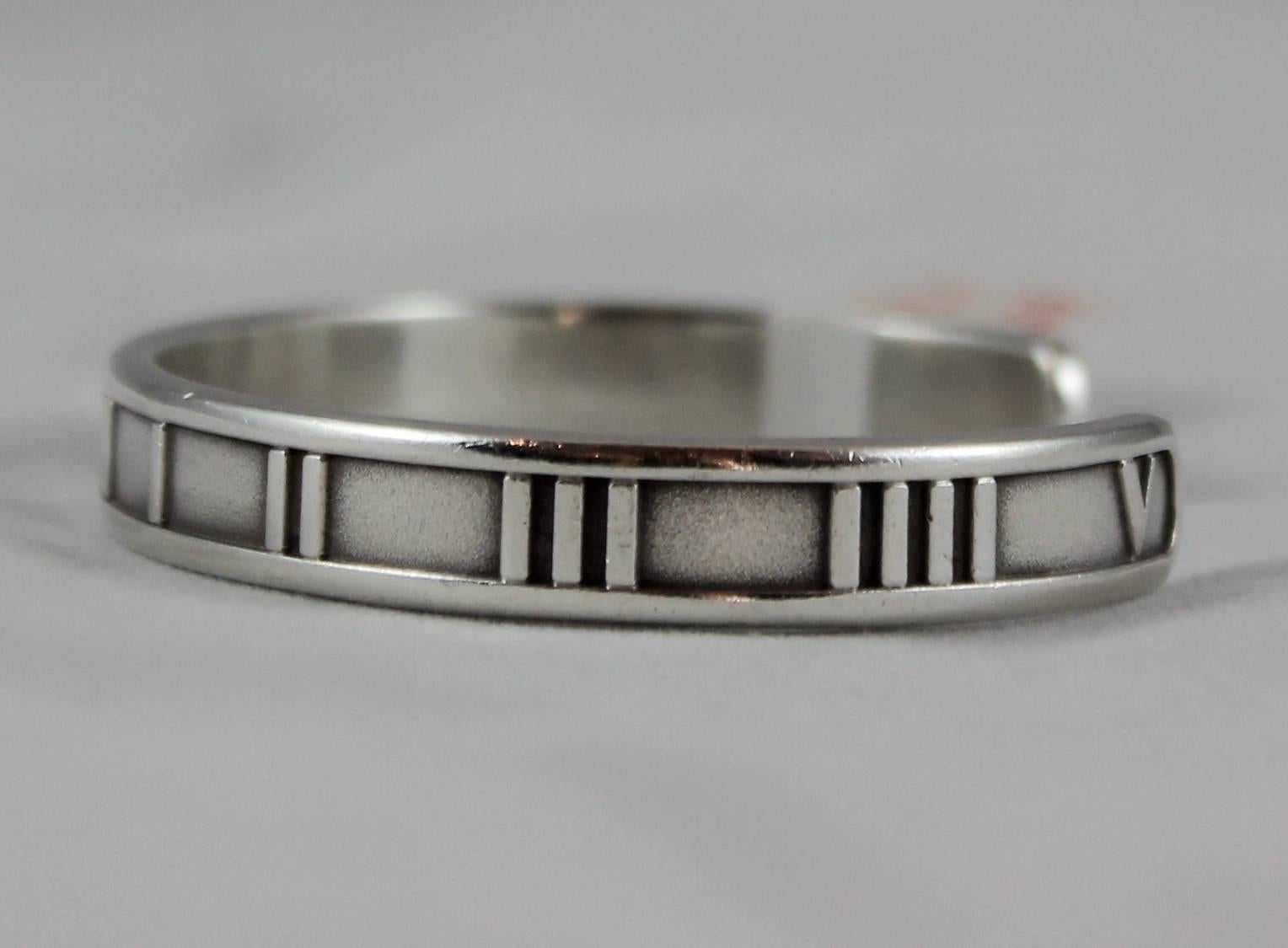 Tiffany & Co. Sterling Silver Atlas Thin Cuff - 1995. This cuff is in excellent vintage condition with light wear consistent with age and minor darkening between the Roman numerals. There is a matching ring available in a size 9.