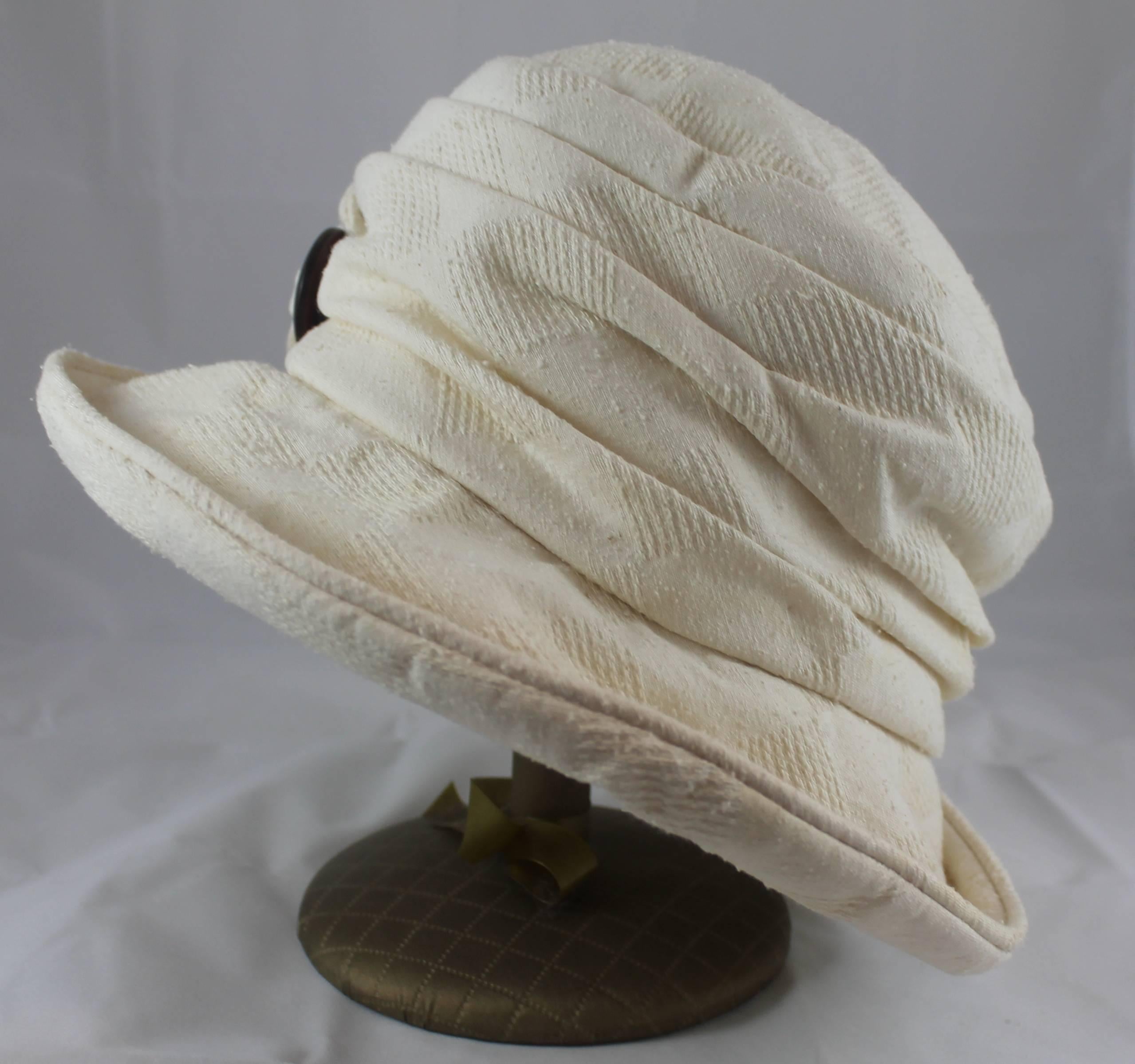 Suzanne Couture Millinery Ivory Cloth Floppy Hat with a Wooden Button. This floppy hat has 