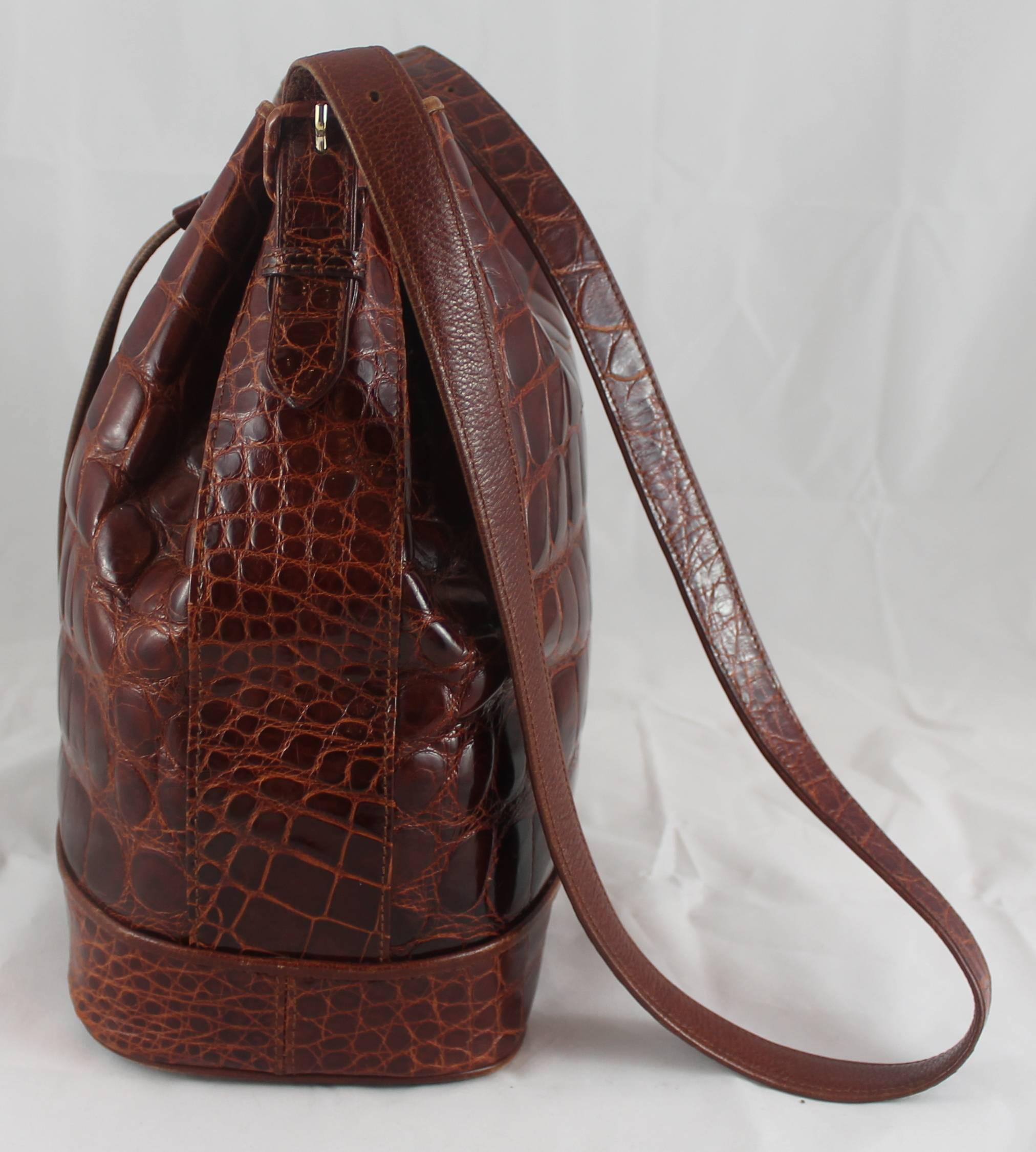 Lana Marks Russet Crocodile Drawstring Bucket Bag. This bag is in good condition with general wear to the bottom, some wear on the buckles, and overall light use. This very trendy bag is unique and is great fro every day. The inside is made of suede